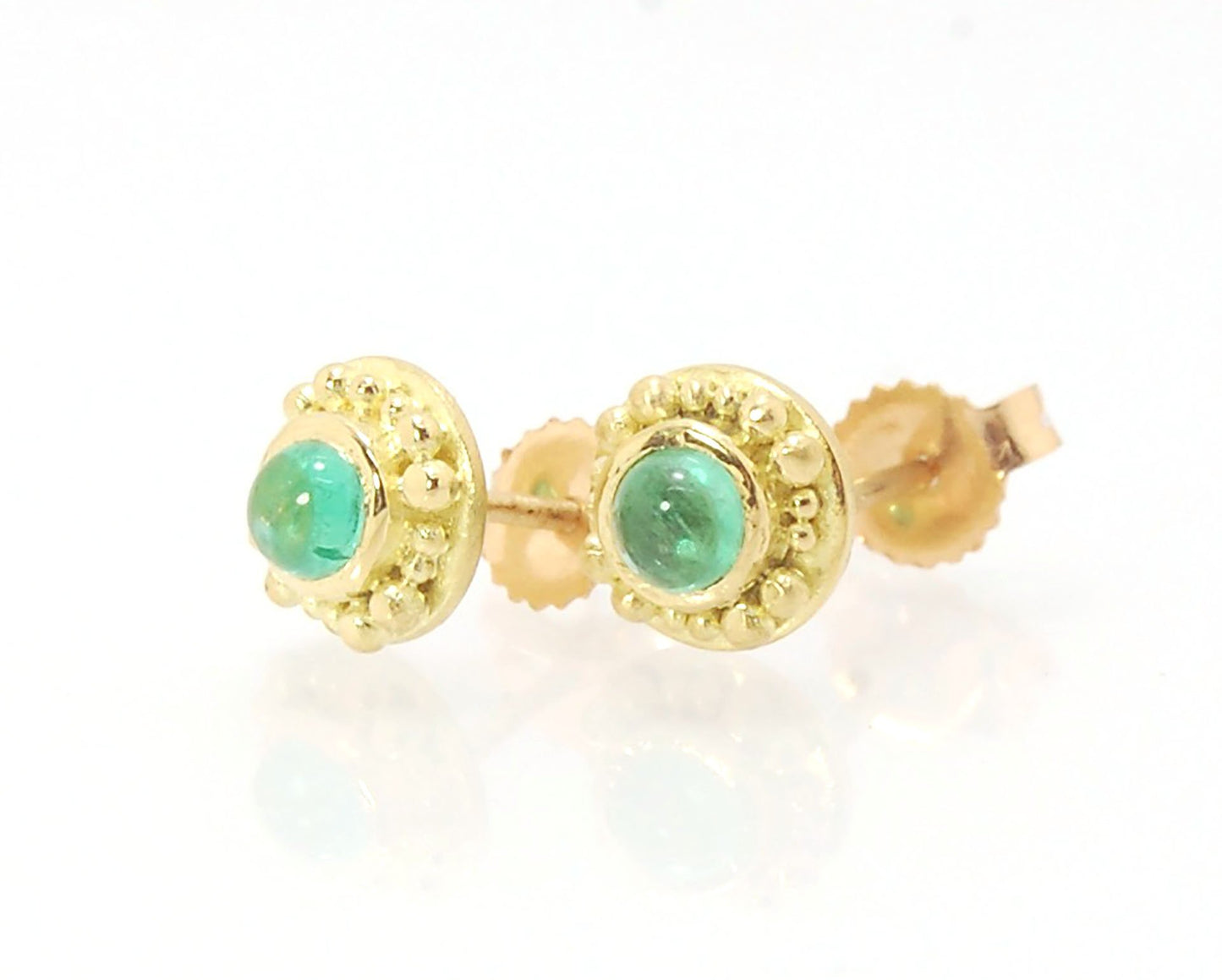 Emerald Cabochon 18k post earrings These stunning emerald cabochons are bezel-set in 18k gold with 18k granulation around the outside. These are 18k gold post earrings with a 14k gold ear nut. Classic and understated. But that color, though! Ya’ll know I