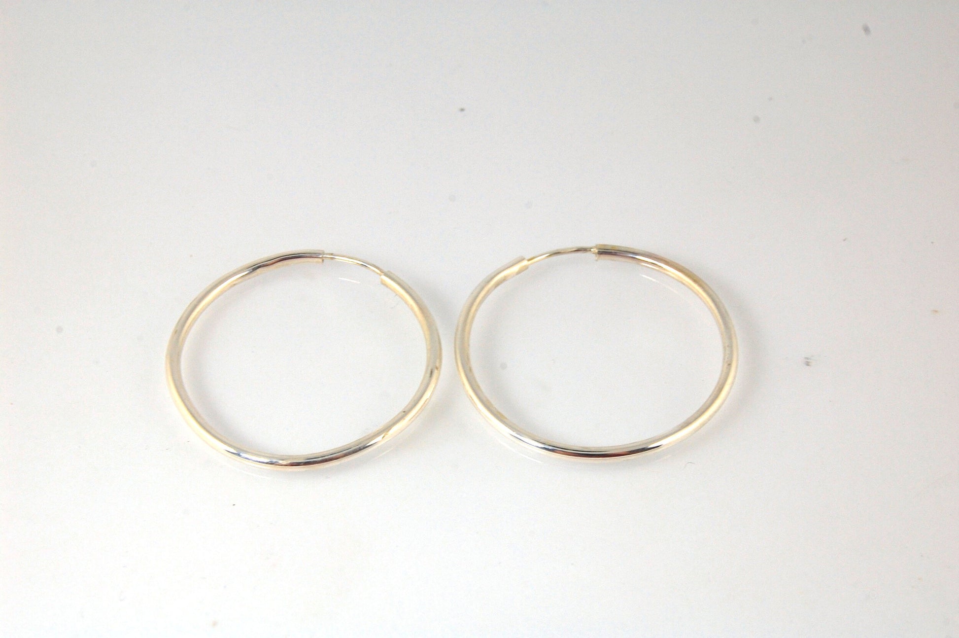 Sterling Eternity Hoops 1" These eternity hoop earrings are secure, lightweight and comfortable to wear everyday.These hoops are 30mm (approx. 1”)Sterling SilverMADE TO ORDER - Ships in 3-10 days