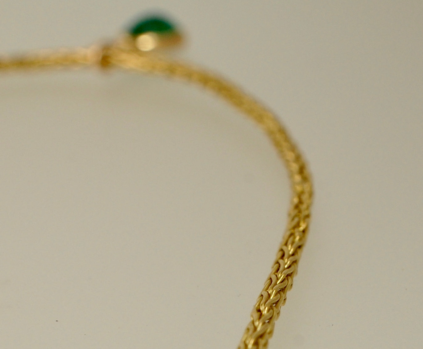 Emerald Cabochon on Handmade Woven 18k gold chain This clear emerald cabochon is bezel-set in 18k gold and suspended from a handmade woven chain of 18k gold in ancient Viking knit. A forged hook clasp finishes this simple and elegant design. Emerald Caboc