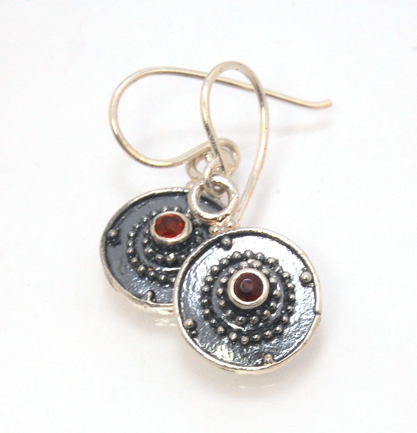 Dangle Shield Earrings in Sterling with Pink Garnet, Red Garnet, Blue Topaz, Peridot, or Amethyst These terrific shield earrings are cast from a granulated original. and is cast using the lost wax process. You can choose which stone to set in your sterlin