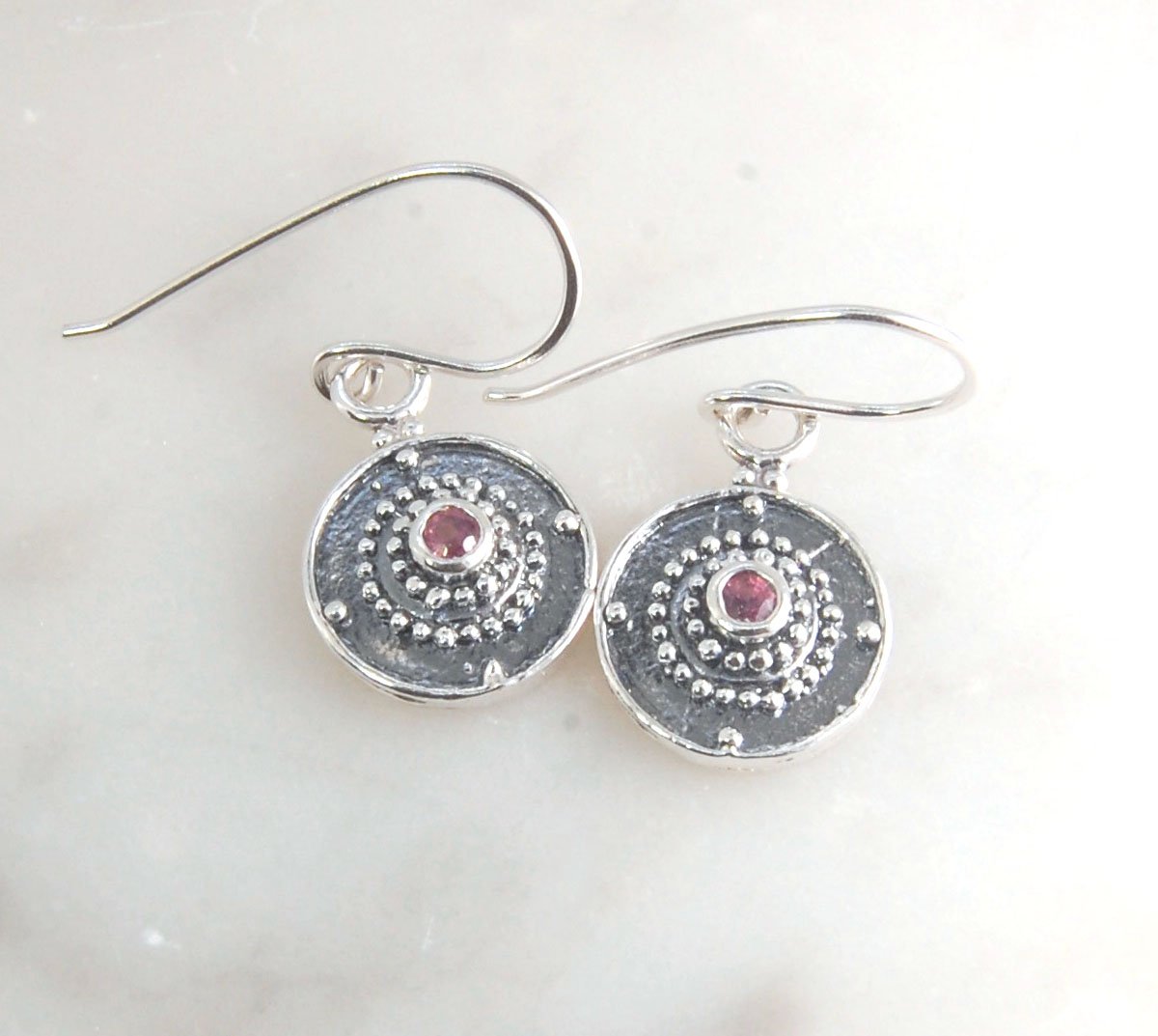 Dangle Shield Earrings in Sterling with Pink Garnet, Red Garnet, Blue Topaz, Peridot, or Amethyst These terrific shield earrings are cast from a granulated original. and is cast using the lost wax process. You can choose which stone to set in your sterlin