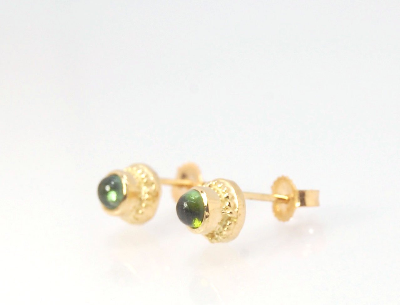 Green Tourmaline Classic Cast Granulation Studs in 14k These are tiny bezel settings I created using the ancient process of granulation. Then I made a mold of it and injected the mold with wax and used that wax to create a 14k gold version of these granul