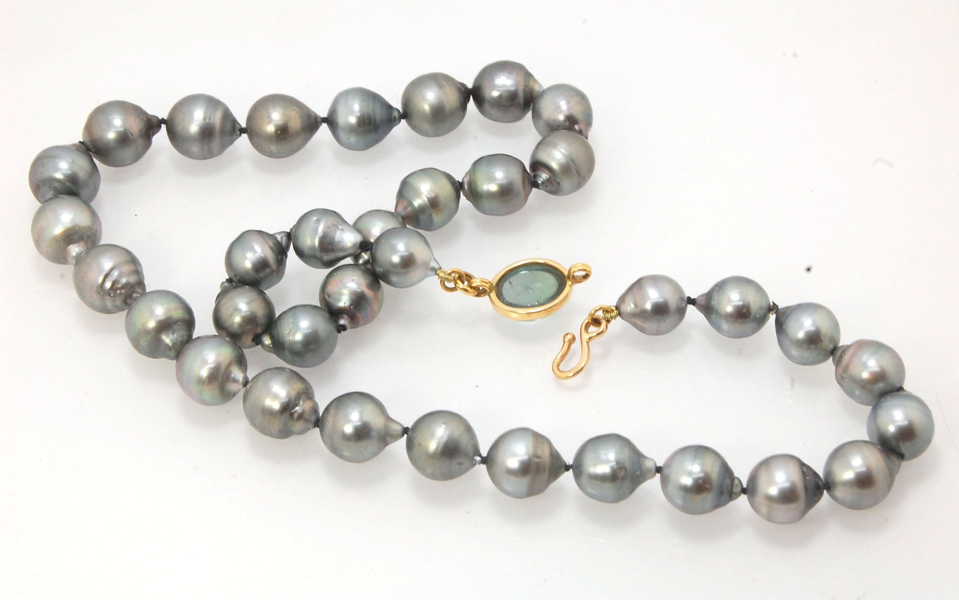 Grey Baroque South Sea Pearl Strand with 18k gold and Tourmaline Clasp This amazingly luminous strand of Grey Baroque South Sea Pearls are 8-10mm each and the strand is slightly graduated. An amazing Bi-color Blue Green Tourmaline cabochon set in 18k with