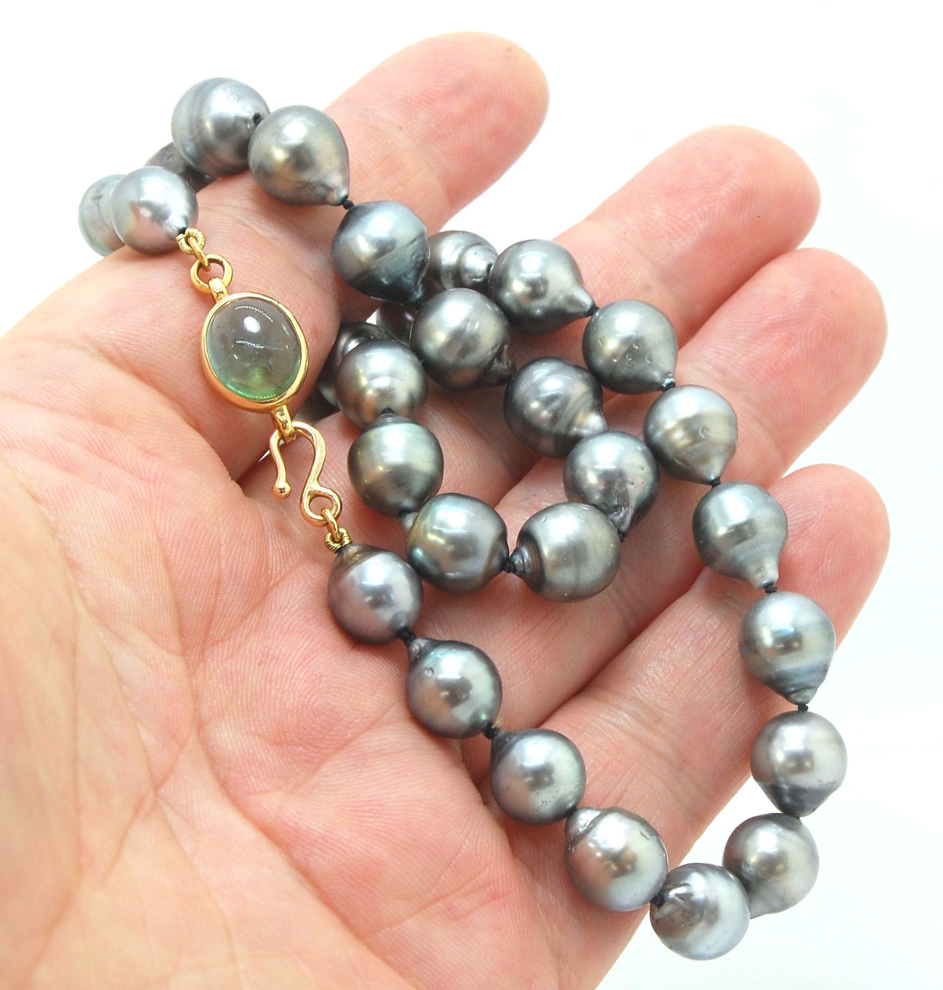 Grey Baroque South Sea Pearl Strand with 18k gold and Tourmaline Clasp This amazingly luminous strand of Grey Baroque South Sea Pearls are 8-10mm each and the strand is slightly graduated. An amazing Bi-color Blue Green Tourmaline cabochon set in 18k with