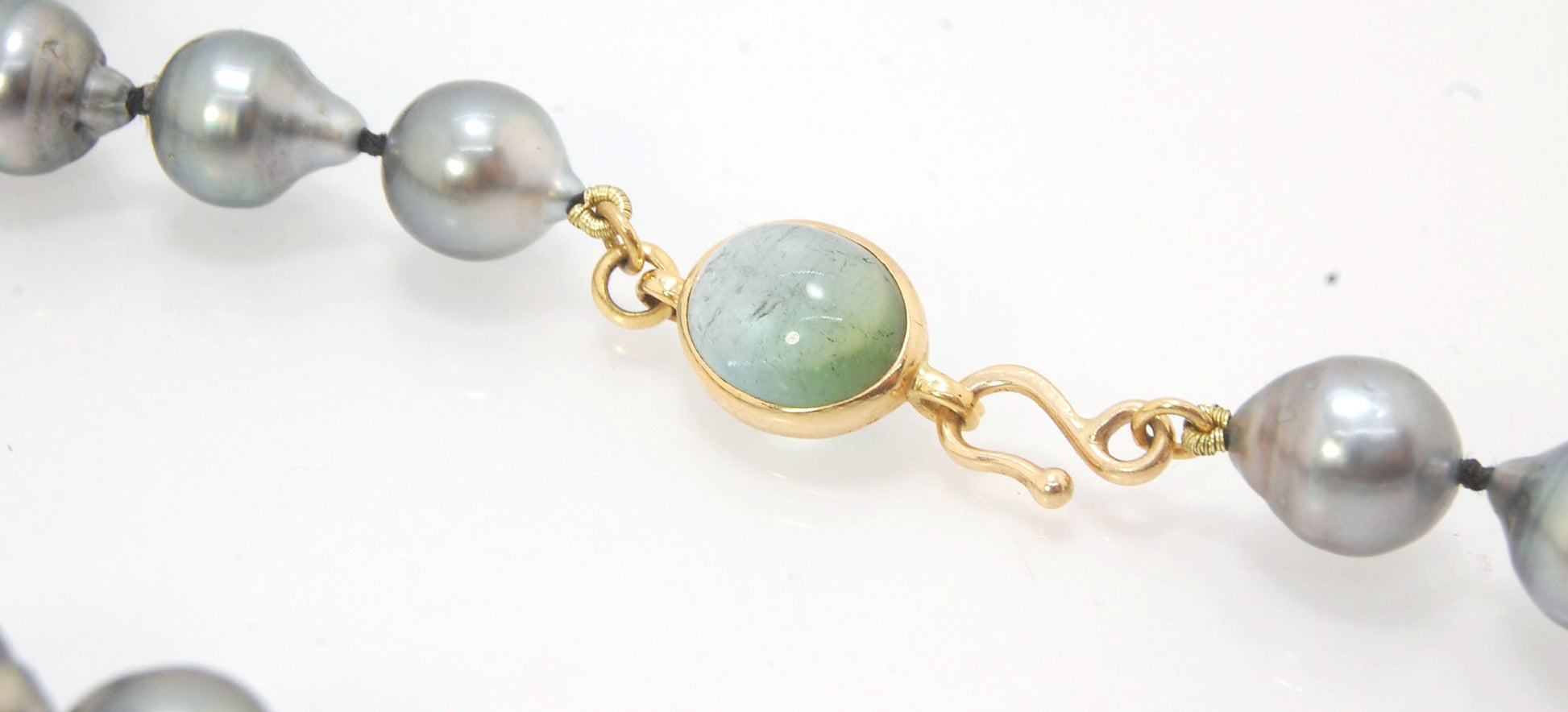 Grey Baroque South Sea Pearl Strand with 18k gold and Tourmaline Clasp This amazingly luminous strand of Grey Baroque South Sea Pearls are 8-10mm each and the strand is slightly graduated. An amazing Bi-color Blue Green Tourmaline cabochon set in 18k with