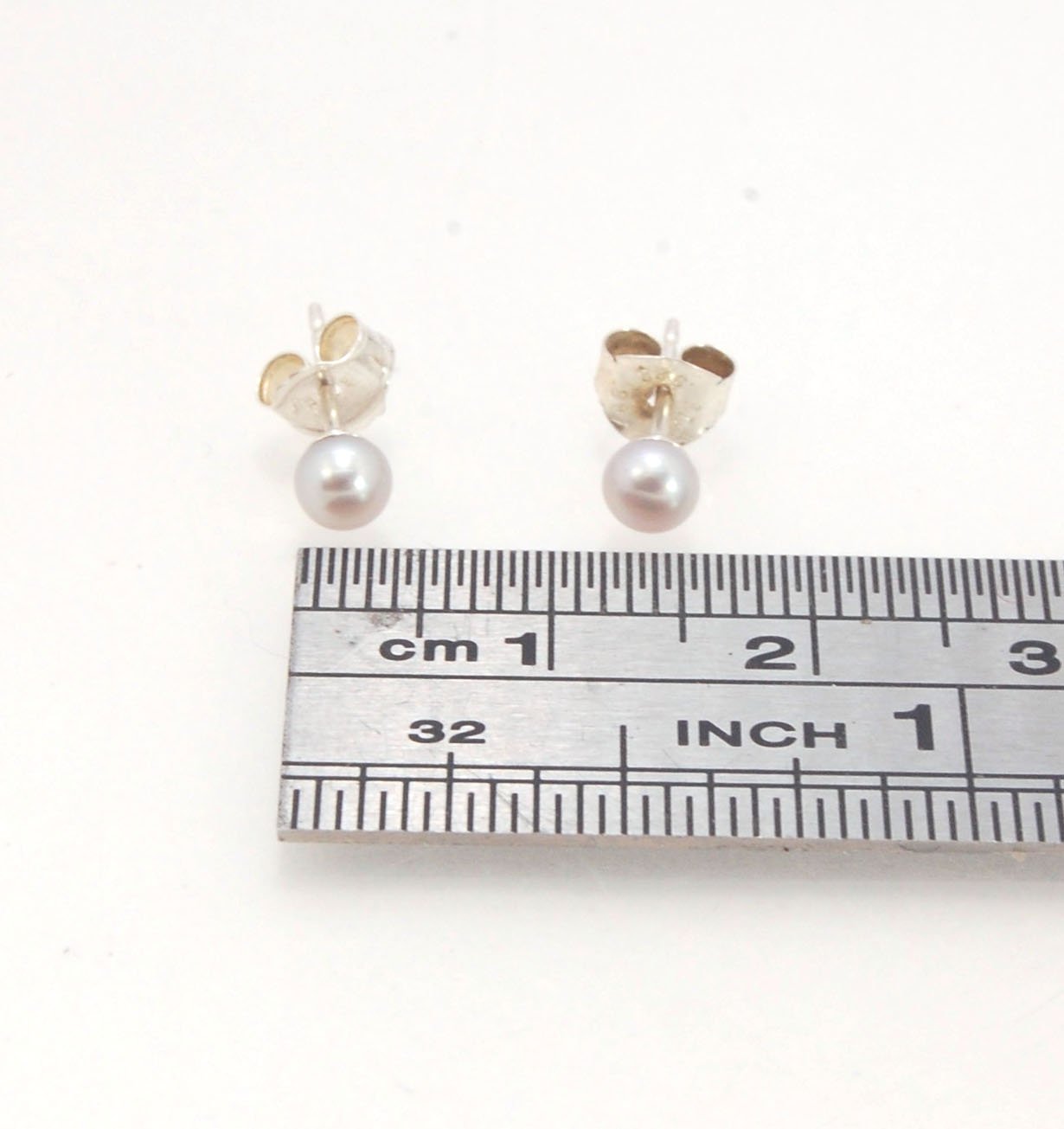 Grey Freshwater pearls studs in Sterling silver - 4mm These tiny luminous grey freshwater pearls are 4mm and set in sterling silver pearl cups and posts with sterling silver ear nuts. Made to Order Sterling and Freshwater pearls