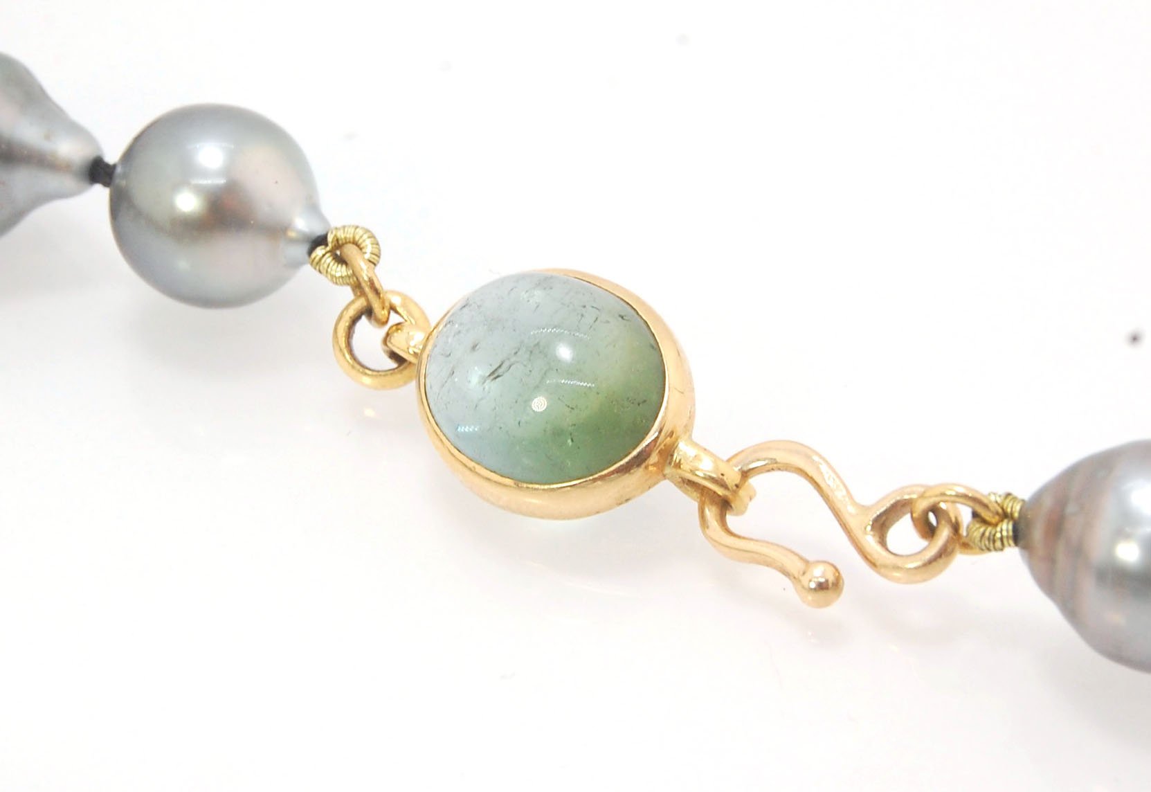 Grey Baroque South Sea Pearl Strand with 18k gold and Tourmaline Clasp This amazingly luminous strand of Grey Baroque South Sea Pearls are 8-10mm each and the strand is slightly graduated. An amazing Bi-color Blue Green Tourmaline cabochon set in 18k with