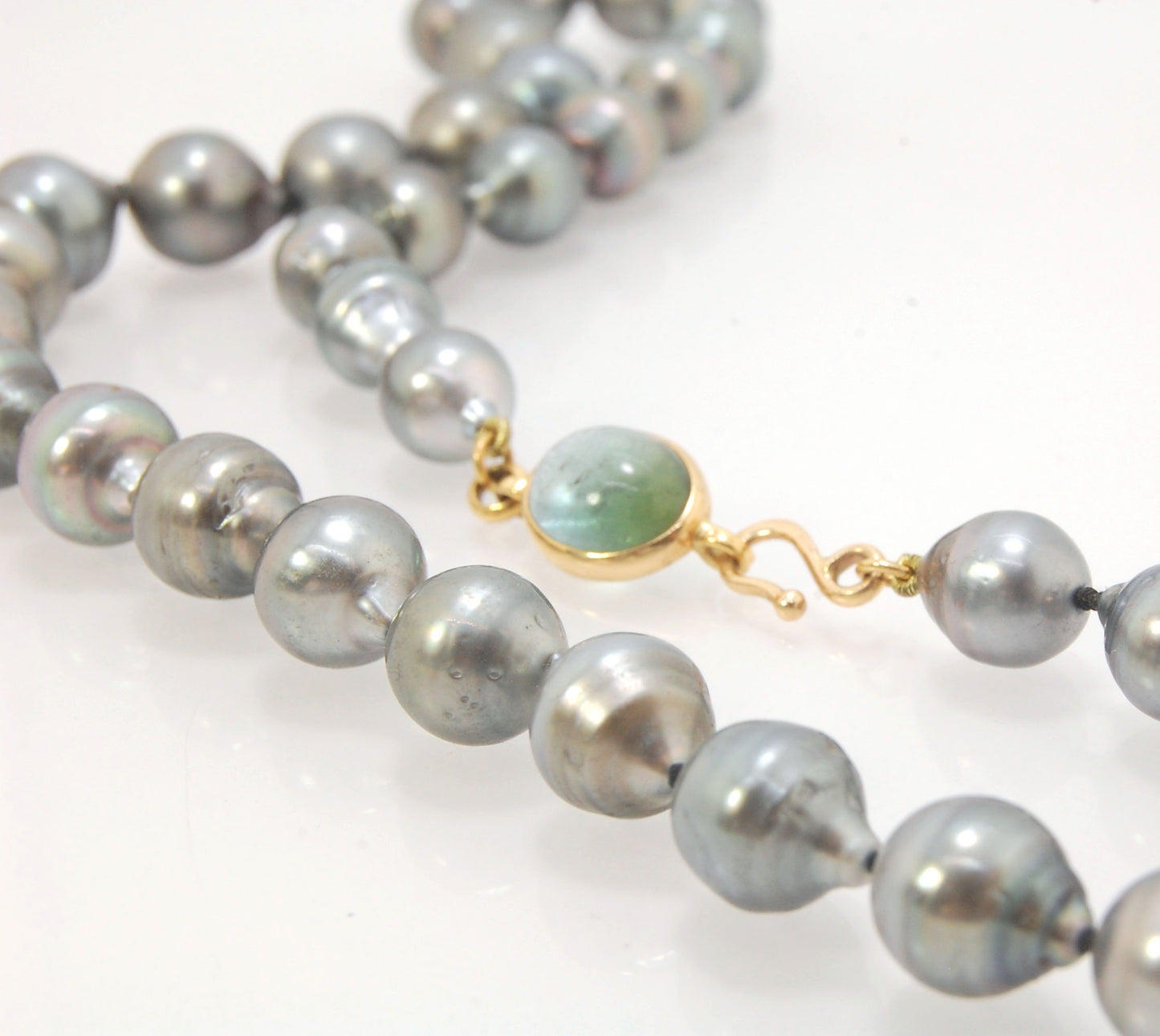 Grey Baroque South Sea Pearl Strand with 18k gold and Tourmaline Clasp This amazingly luminous strand of Grey Baroque South Sea Pearls are 8-10mm each and the strand is slightly graduated. An amazing Bi-color Blue Green Tourmaline cabochon set in 18k with