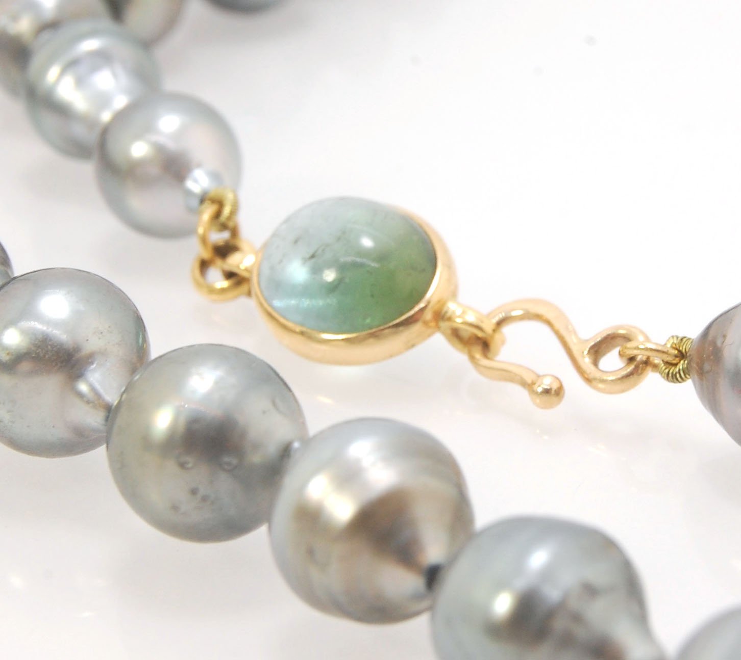 Grey Baroque South Sea Pearl Strand with 18k gold and Tourmaline Clasp This amazingly luminous strand of Grey Baroque South Sea Pearls are 8-10mm each and the strand is slightly graduated. An amazing Bi-color Blue Green Tourmaline cabochon set in 18k with