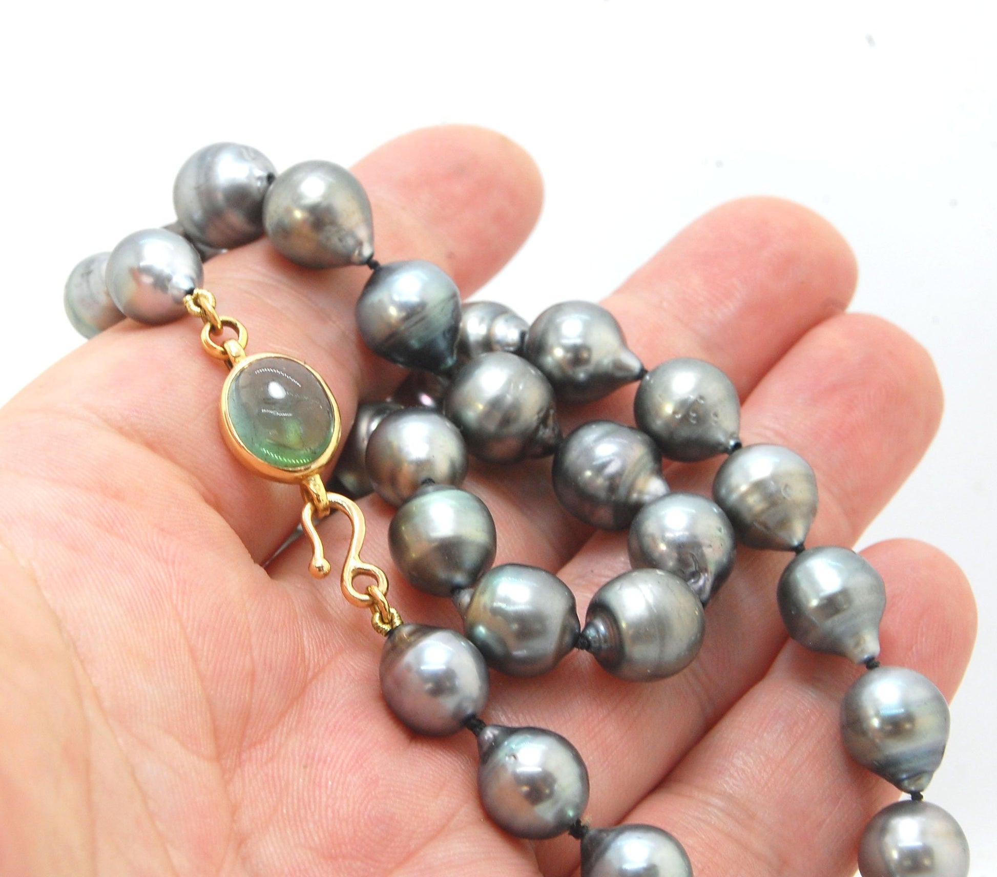 Grey Baroque South Sea Pearl Strand with 18k gold and Tourmaline Clasp This amazingly luminous strand of Grey Baroque South Sea Pearls are 8-10mm each and the strand is slightly graduated. An amazing Bi-color Blue Green Tourmaline cabochon set in 18k with