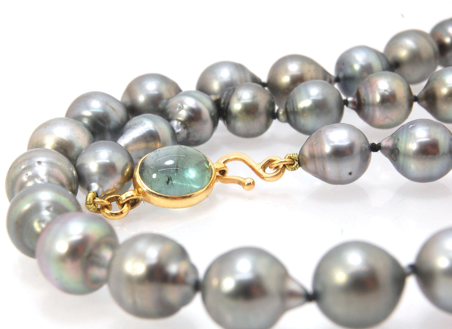 Grey Baroque South Sea Pearl Strand with 18k gold and Tourmaline Clasp This amazingly luminous strand of Grey Baroque South Sea Pearls are 8-10mm each and the strand is slightly graduated. An amazing Bi-color Blue Green Tourmaline cabochon set in 18k with