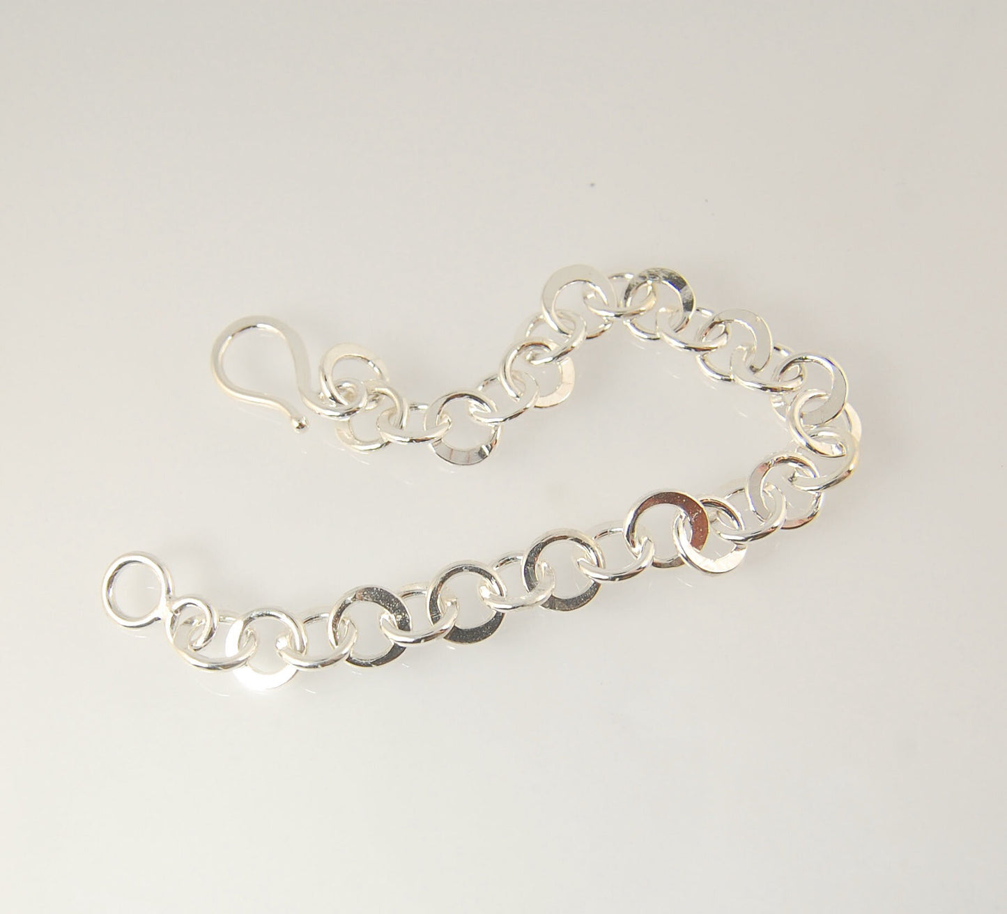 Moonshaped Silver Hammered Link Bracelet These are fun and eye-catching silver bracelets! They have a nice weight without being heavy. Each link is soldered and hammered in a moon pattern for a shimmery look. Each has a forged hook clasp. Each link is for