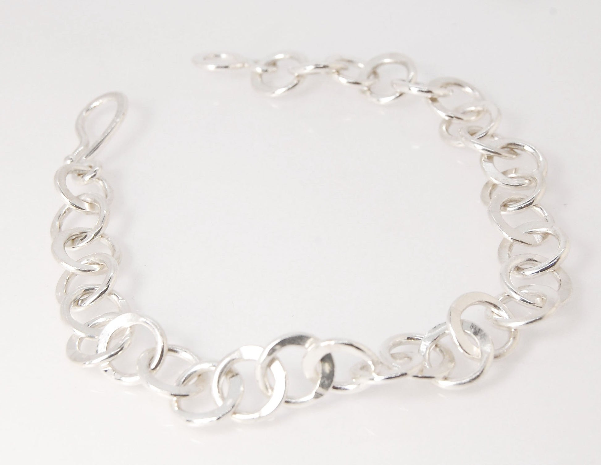 Moonshaped Silver Hammered Link Bracelet These are fun and eye-catching silver bracelets! They have a nice weight without being heavy. Each link is soldered and hammered in a moon pattern for a shimmery look. Each has a forged hook clasp. Each link is for