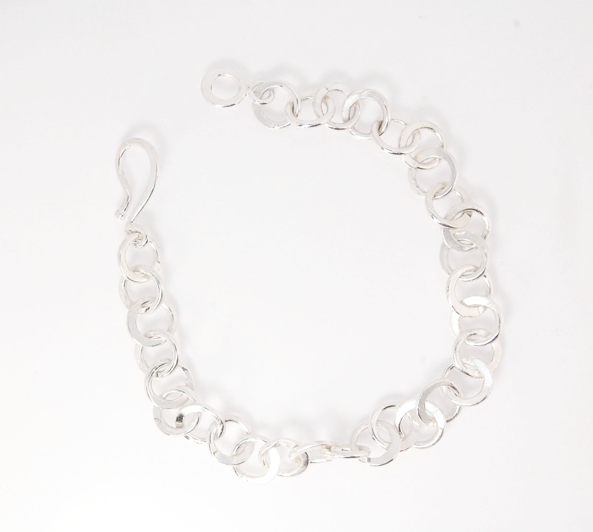 Moonshaped Silver Hammered Link Bracelet These are fun and eye-catching silver bracelets! They have a nice weight without being heavy. Each link is soldered and hammered in a moon pattern for a shimmery look. Each has a forged hook clasp. Each link is for