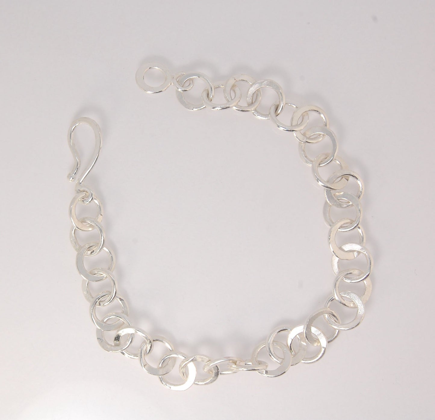 Moonshaped Silver Hammered Link Bracelet These are fun and eye-catching silver bracelets! They have a nice weight without being heavy. Each link is soldered and hammered in a moon pattern for a shimmery look. Each has a forged hook clasp. Each link is for