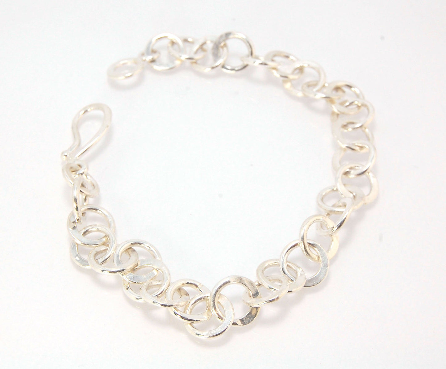 Moonshaped Silver Hammered Link Bracelet These are fun and eye-catching silver bracelets! They have a nice weight without being heavy. Each link is soldered and hammered in a moon pattern for a shimmery look. Each has a forged hook clasp. Each link is for