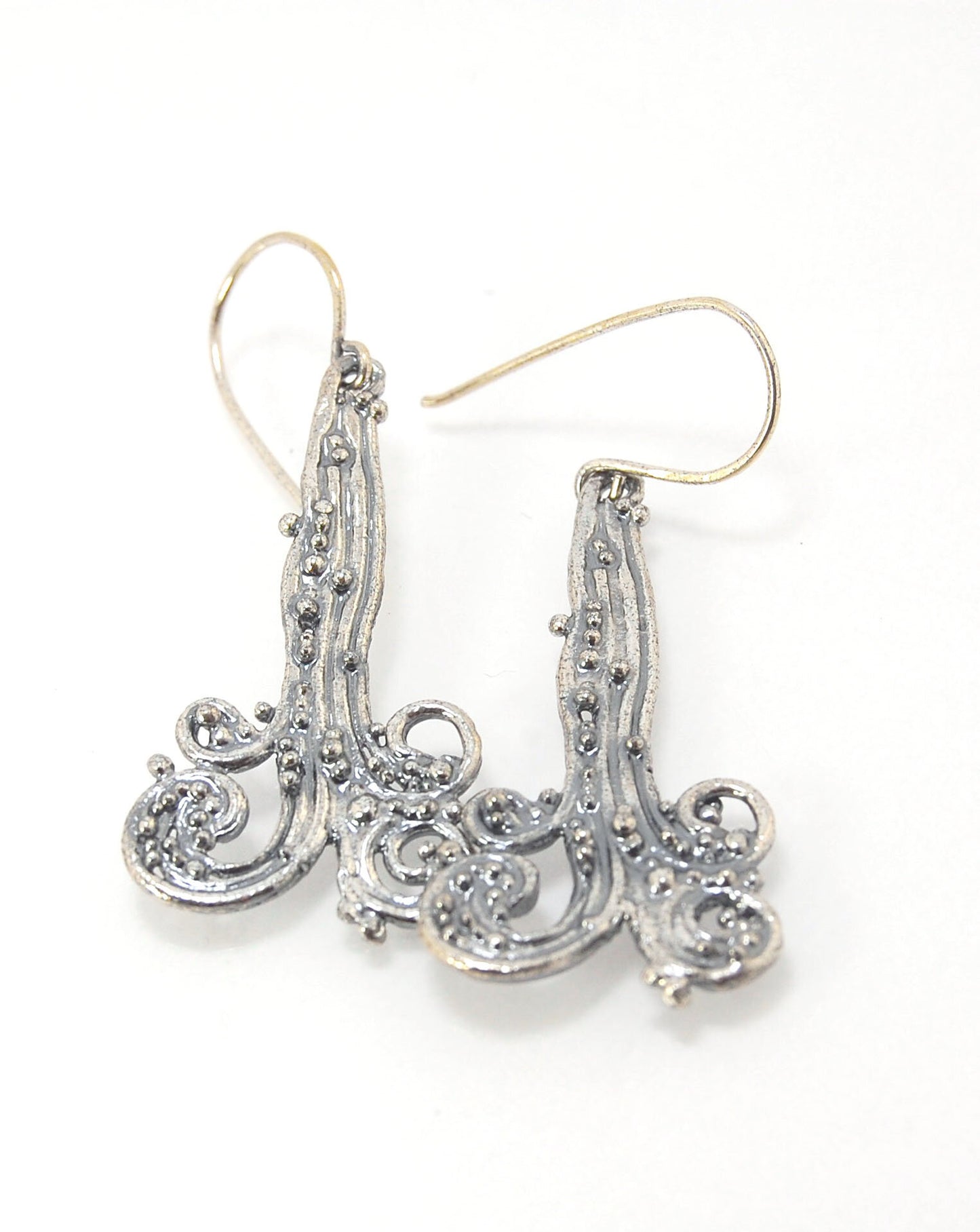 Waterfall Earrings These long Wave Dangles are part of my new work. These are cast versions of my original granulation work, which is then molded for repeat waxes and then cast using the Lost Wax process.These waterfall dangles have a dark patina and are