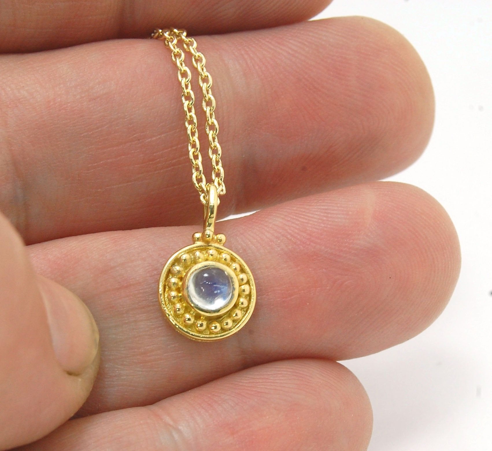 Tiny Round Rainbow Moonstone 18k gold Granulated Pendant This beautiful tiny round rainbow moonstone has so much luminance! A bezel-set small round rainbow moonstone is surrounded by larger 18k gold granules and can be ordered on the your chain of choice.