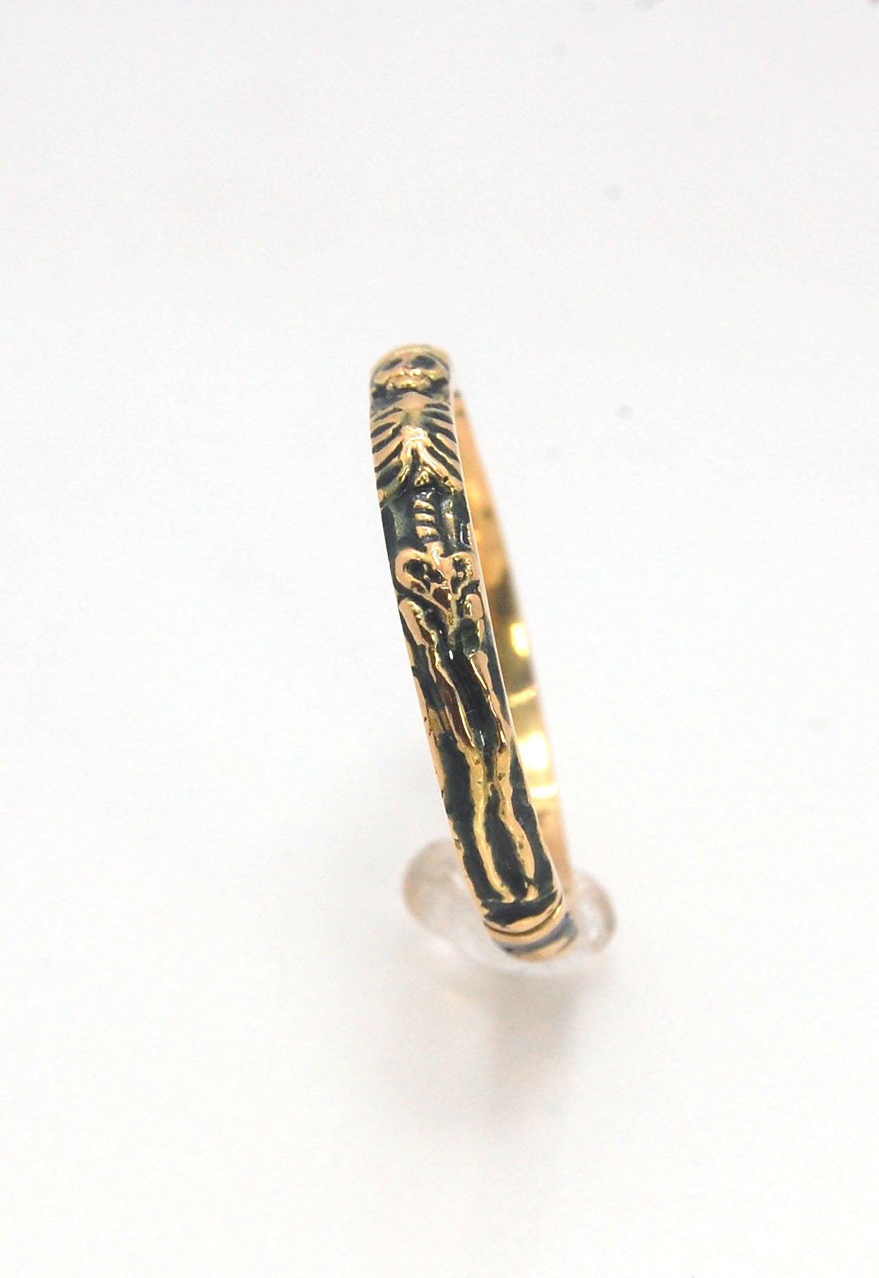 Memento Mori Skeleton Ring in 14k gold - 3mm This is the most narrow of my Memento Mori rings at 3mm wide and is cast in 14k rich yellow gold. The Skeleton is flanked by intertwined hearts on one side.14k rich yellow gold and EnamelMade to Order. Usually