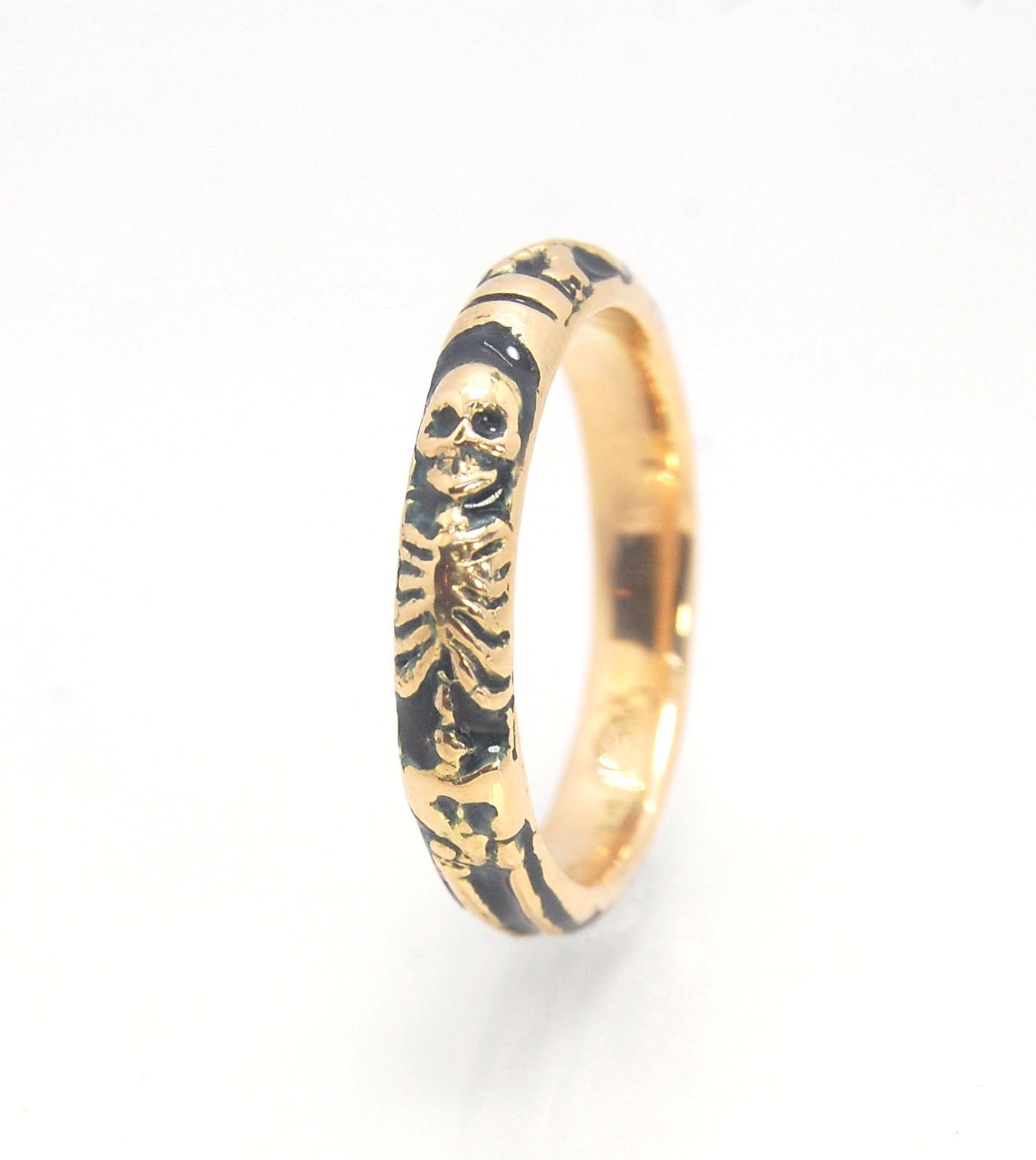 Memento Mori Skeleton Ring in 14k gold with enamel - Medium - 4mm This is the middle width of my Memento Mori skeleton rings at 4mm wide and cast in 14k rich yellow gold. The Skeleton is flanked by crossed bones on one side and an hourglass on the other.1