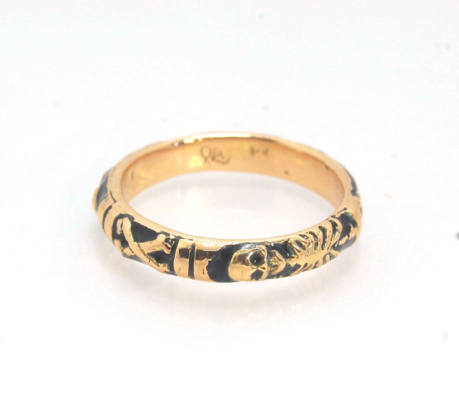 Memento Mori Skeleton Ring in 14k gold with enamel - Medium - 4mm This is the middle width of my Memento Mori skeleton rings at 4mm wide and cast in 14k rich yellow gold. The Skeleton is flanked by crossed bones on one side and an hourglass on the other.1