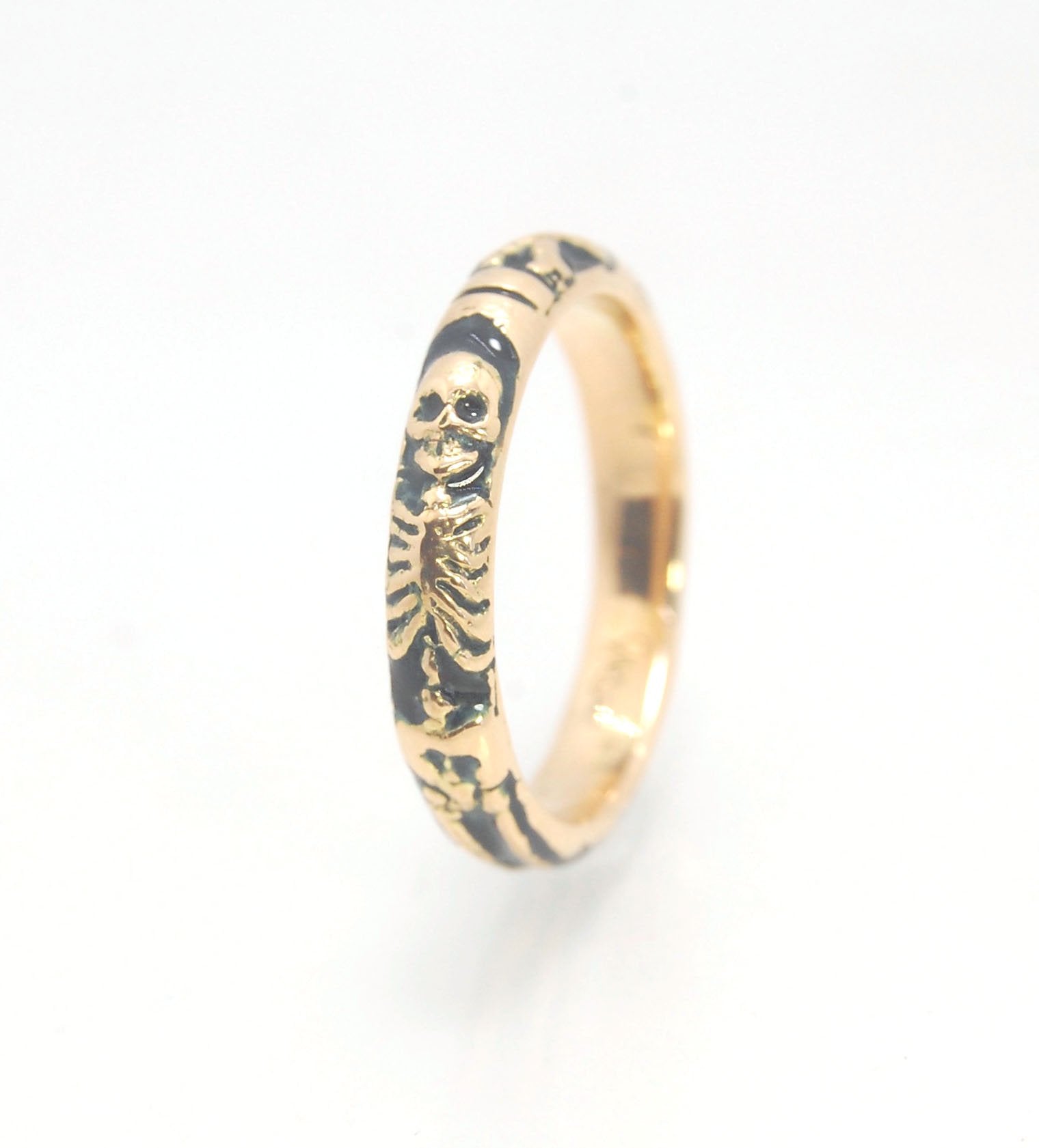 Memento Mori Skeleton Ring in 14k gold with enamel - Medium - 4mm This is the middle width of my Memento Mori skeleton rings at 4mm wide and cast in 14k rich yellow gold. The Skeleton is flanked by crossed bones on one side and an hourglass on the other.1