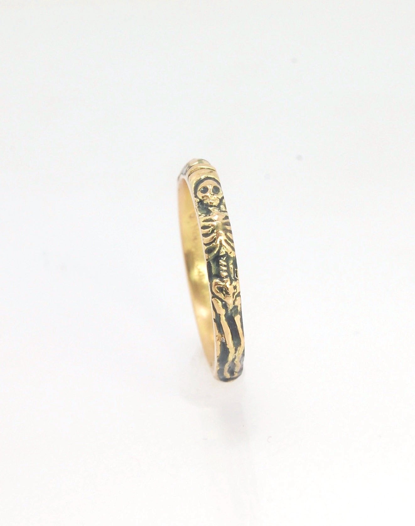 Memento Mori Skeleton Ring in 14k gold - 3mm This is the most narrow of my Memento Mori rings at 3mm wide and is cast in 14k rich yellow gold. The Skeleton is flanked by intertwined hearts on one side.14k rich yellow gold and EnamelMade to Order. Usually