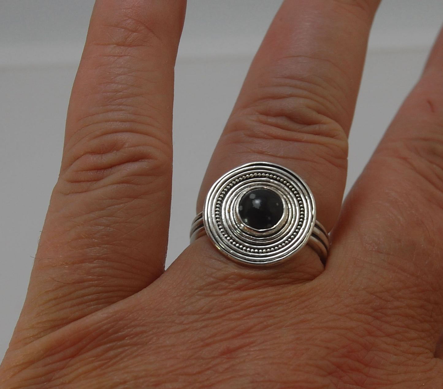 Orbit Ring with Snowflake Jasper Snowflake Jasper Cabochon bezel-set in fine silver granulation with concentric rings and a sterling silver shank cast from an original wax turned ring cast on site. Granulation is a controlled fusing process that has been