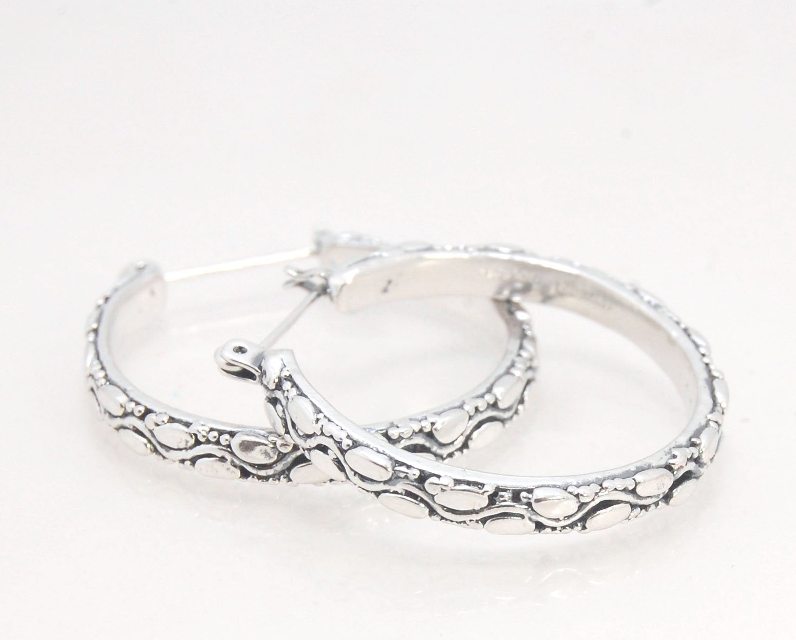 Ovals Pattern Hoops - Sterling in 3 sizes These Hoops are made from an Ovals pattern with heavy granules and ingot slices and have a hoop catch with a satisfying snap.These Ovals Hoops come in 3 sizes Large - 3mm wide and 1.25” in diameterMedium - 3mm wid