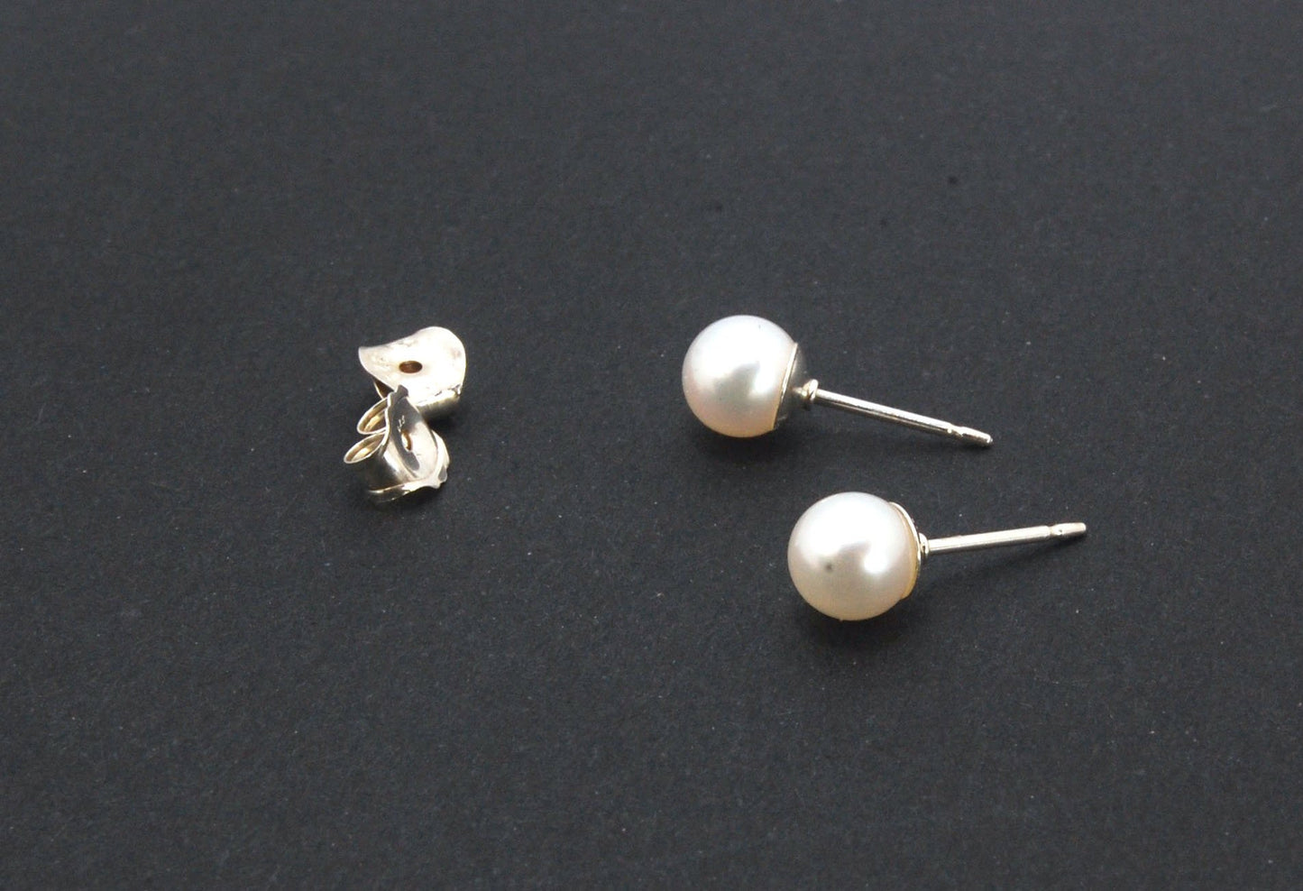 Freshwater White pearls studs in Sterling silver - 6mm These luminous white freshwater pearls are 6mm and set in sterling silver pearl cups and posts with sterling silver ear nuts.6mmSterling Silver and freshwater pearl