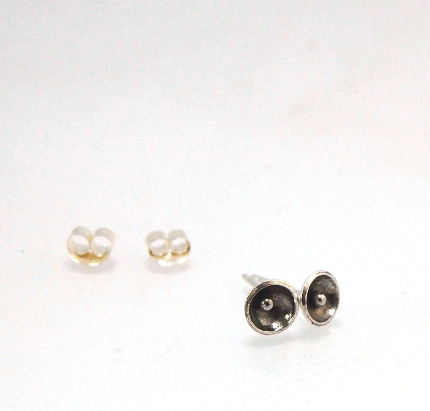 Poppy Post Earrings in Fine Silver These are tiny Fine Silver disks rounded into bowls with a tiny ball in the center to resemble a poppy. These are created using the ancient process of Granulation.6mmFine Silver Poppy, Sterling Post and EarnutMade to Ord