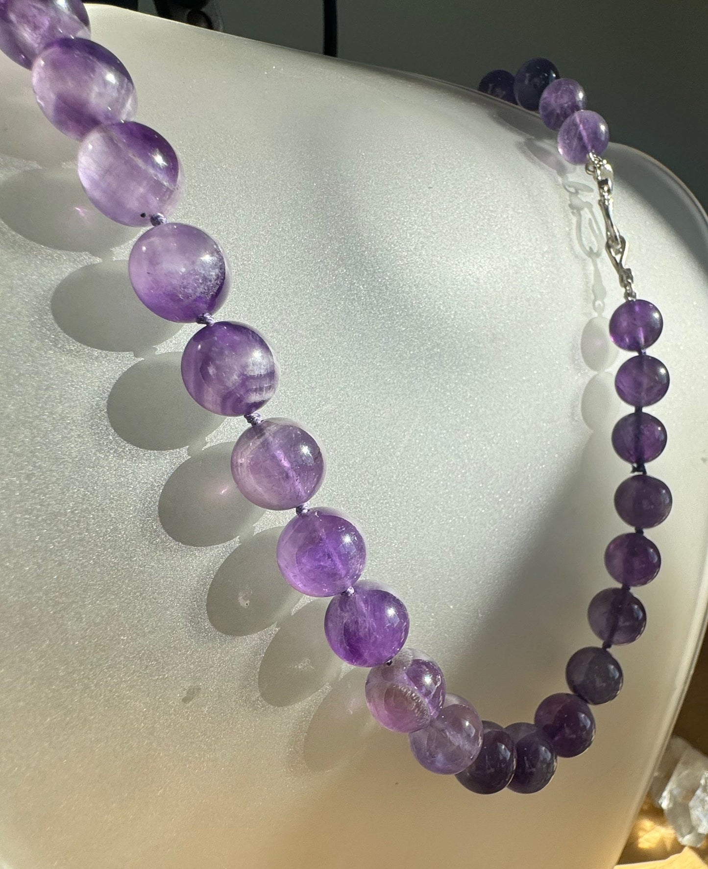 Round Amethyst Gemstone Knotted Strand These lovely round Amethyst Gemstone Beads are a large 11.5mm! These beauties have a nice weight and warmth and are knotted on silk like pearls. I have made a sterling silver two-part clasp with faceted amethysts and