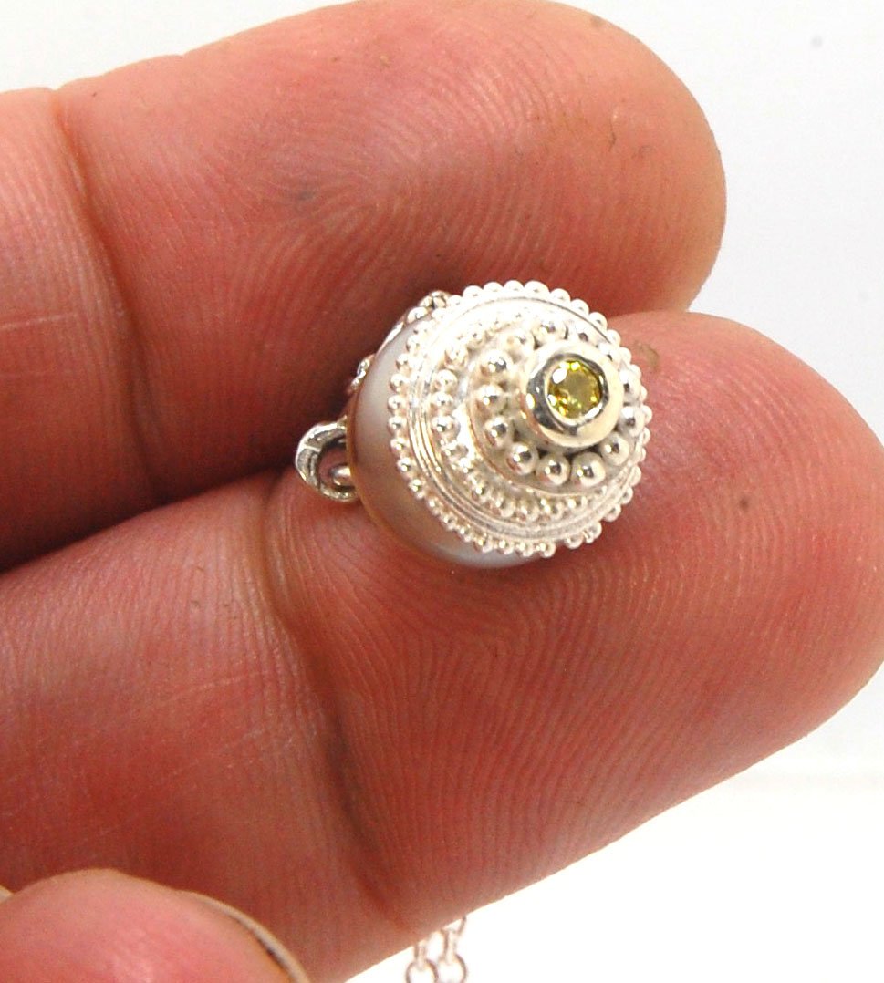 Grey Baroque Pearl with Fine Silver Granulation and Yellow Sapphire Grey Baroque Pearl with Fine Silver Granulation and Yellow SapphireThis grey baroque pearl is capped with one-of-a-kind fine silver granulation and a bezel set 2mm faceted yellow sapphire