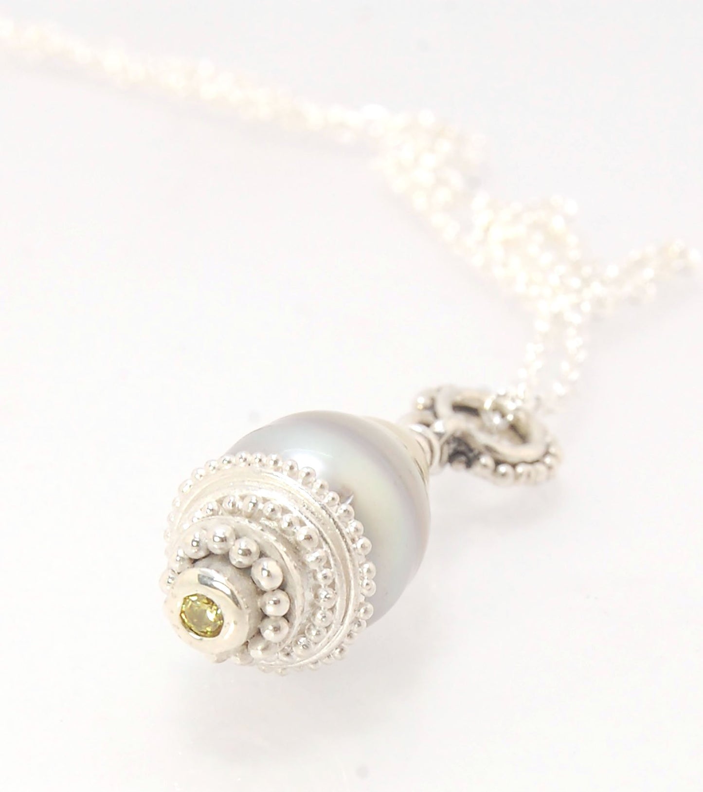 Grey Baroque Pearl with Fine Silver Granulation and Yellow Sapphire Grey Baroque Pearl with Fine Silver Granulation and Yellow SapphireThis grey baroque pearl is capped with one-of-a-kind fine silver granulation and a bezel set 2mm faceted yellow sapphire