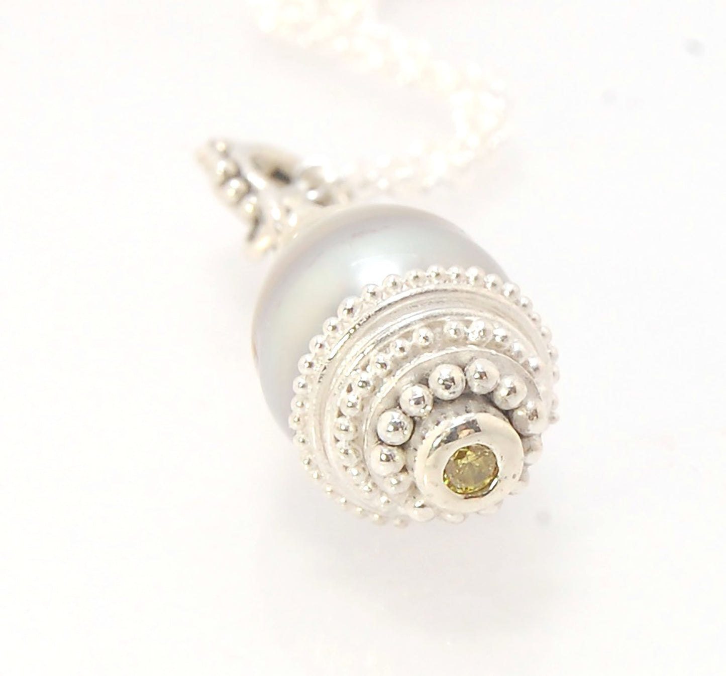 Grey Baroque Pearl with Fine Silver Granulation and Yellow Sapphire Grey Baroque Pearl with Fine Silver Granulation and Yellow SapphireThis grey baroque pearl is capped with one-of-a-kind fine silver granulation and a bezel set 2mm faceted yellow sapphire