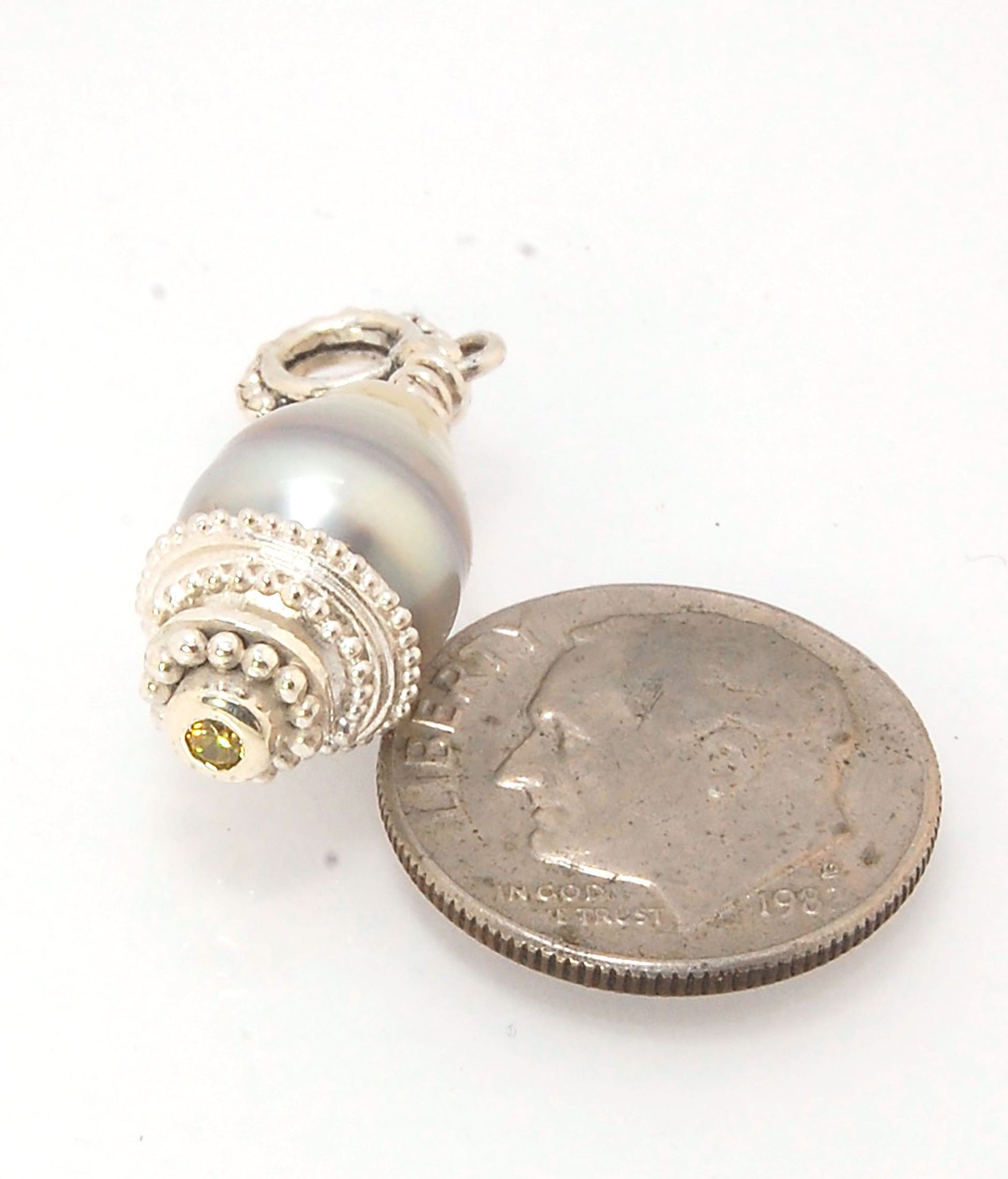 Grey Baroque Pearl with Fine Silver Granulation and Yellow Sapphire Grey Baroque Pearl with Fine Silver Granulation and Yellow SapphireThis grey baroque pearl is capped with one-of-a-kind fine silver granulation and a bezel set 2mm faceted yellow sapphire