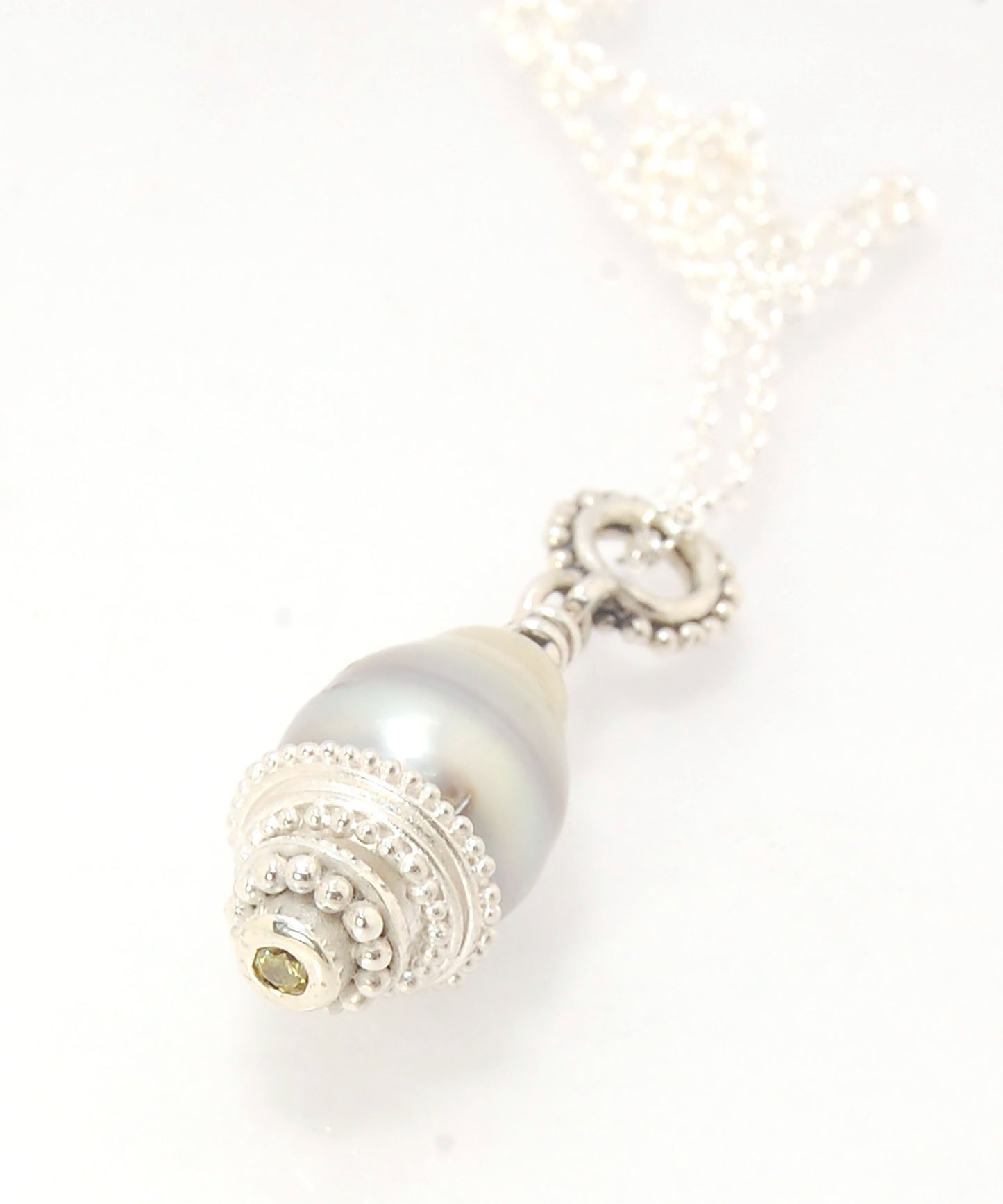 Grey Baroque Pearl with Fine Silver Granulation and Yellow Sapphire Grey Baroque Pearl with Fine Silver Granulation and Yellow SapphireThis grey baroque pearl is capped with one-of-a-kind fine silver granulation and a bezel set 2mm faceted yellow sapphire