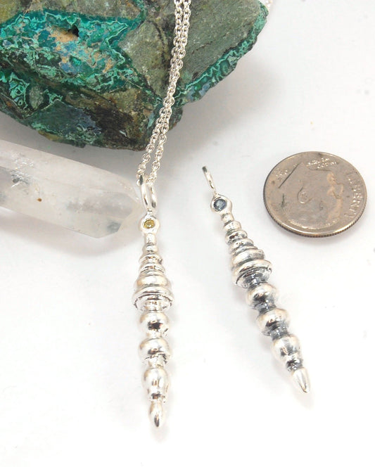 Seashell Pendulum Sterling This is part of a fun series of lathe-turned wax pieces. This seashell pendulum is elegant and feminine and mysterious.Carved in wax and cast using a lost-wax casting process, this piece is cast in sterling silver and can have a