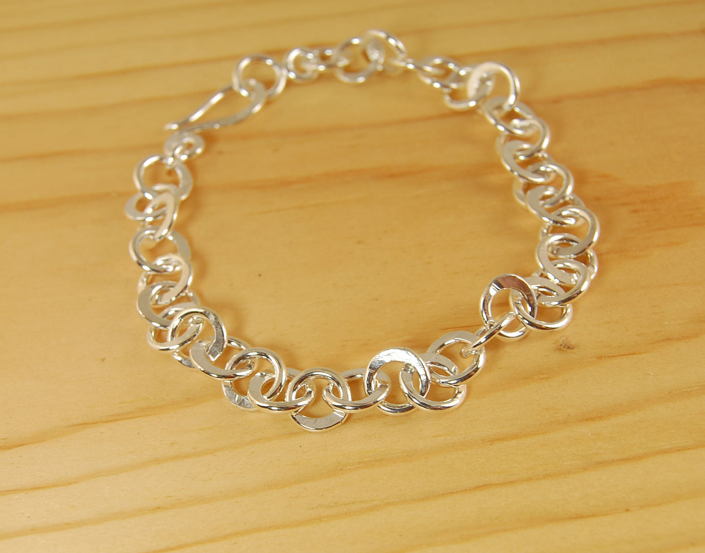 Moonshaped Silver Hammered Link Bracelet These are fun and eye-catching silver bracelets! They have a nice weight without being heavy. Each link is soldered and hammered in a moon pattern for a shimmery look. Each has a forged hook clasp. Each link is for