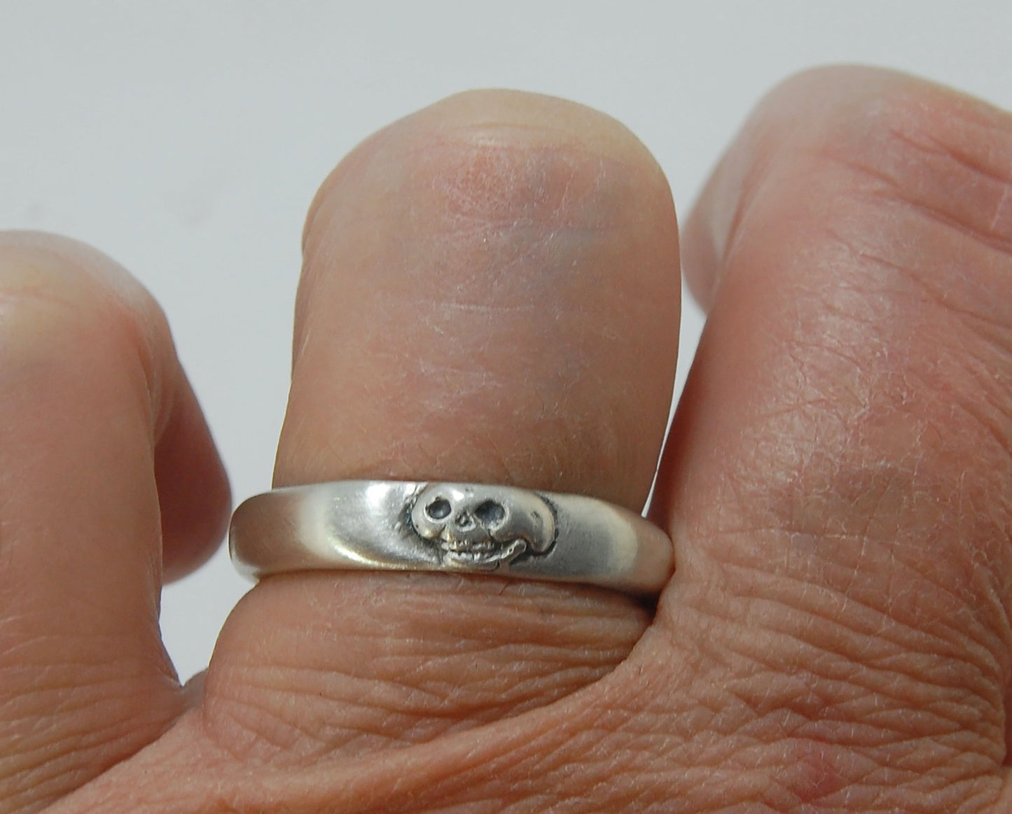 Memento Mori Skull Ring - Narrow This is narrow one of my two Memento Mori skull rings at 4mm. Cast in sterling silver and given a brushed finish after oxidizing the recesses of the skull. Heavyweight, very comfortable.SterlingI made these Memento Mori ri