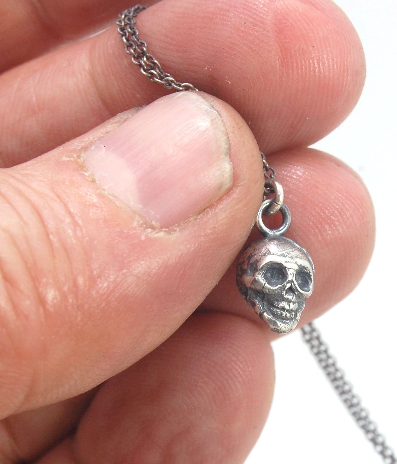 Tiny Skull Charm Pendant This solid sterling silver Skull Pendant is wax carved by hand and cast using the ancient process of Lost Wax casting. I then made a mold, which I can inject with wax and make wax copies of the Jolly Roger Pendant and cast a lot o