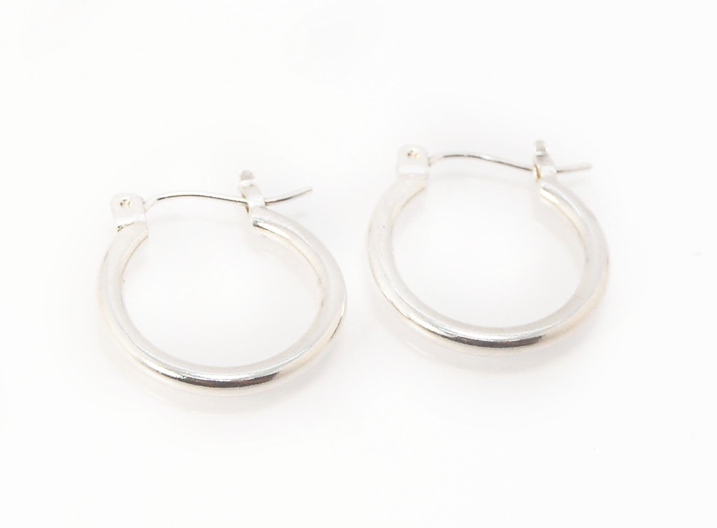 Solid Hoops with clasp in Silver - Medium These hoops are great for everyday wear. Classic and understated at 16mm or about 1/2”.These are made with a solid round rod cut into links and hammered with a clasp ear wire soldered on. Then polished and finishe