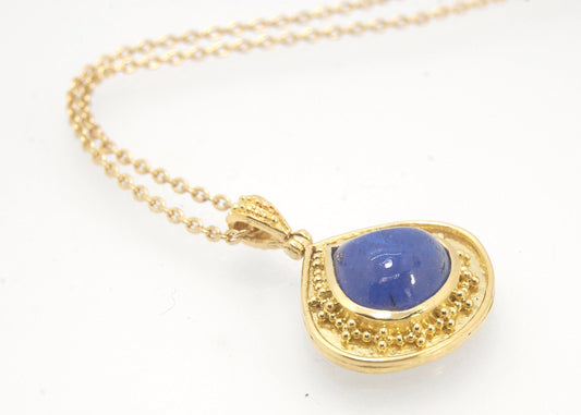 Blue Drop Tanzanite Cabochon 18k Gold Granulation Pendant and 14k 18" Chain This super blue teardrop-shaped Tanzanite is bezel-set in rich 18k gold bezel setting surrounded by 18k gold granulation with a granulated bail that has been riveted on for more m