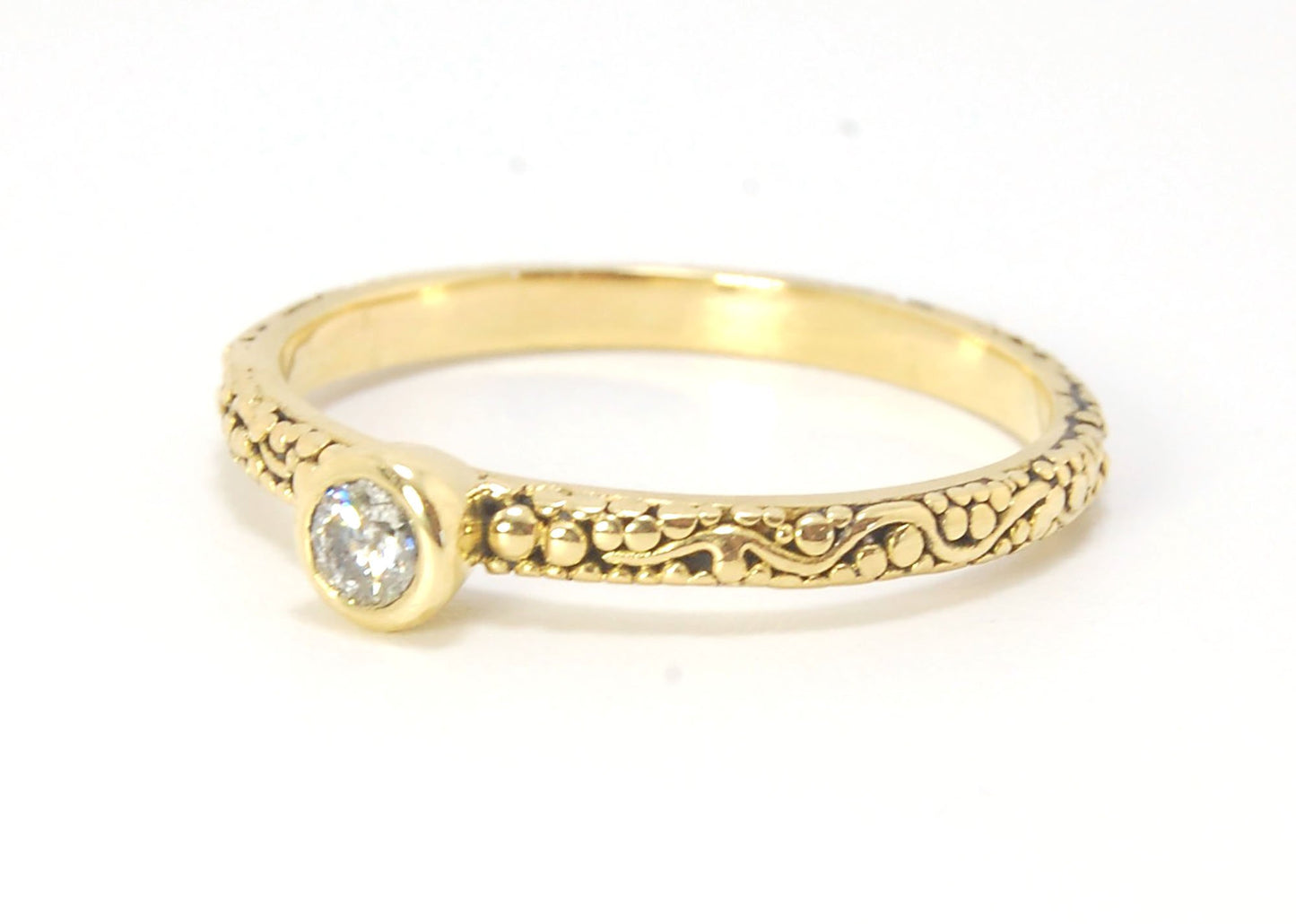 Twining Band Diamond Solitaire Ring in 18k Granulation This is a one-of-a-kind solitaire 18k ring. The twining band is 2mm wide and has a continuous pattern around made with an ancient and unique process of granulation in 18k gold alloyed in my studio. Th