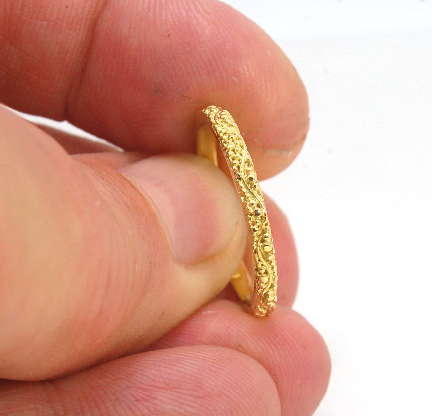 Twining Band in 18k Granulation This is a one-of-a-kind 18k ring handmade using the ancient process of granulation. The twining band is 2mm wide and has a continuous pattern around made with an ancient and unique process of granulation in 18k gold alloyed