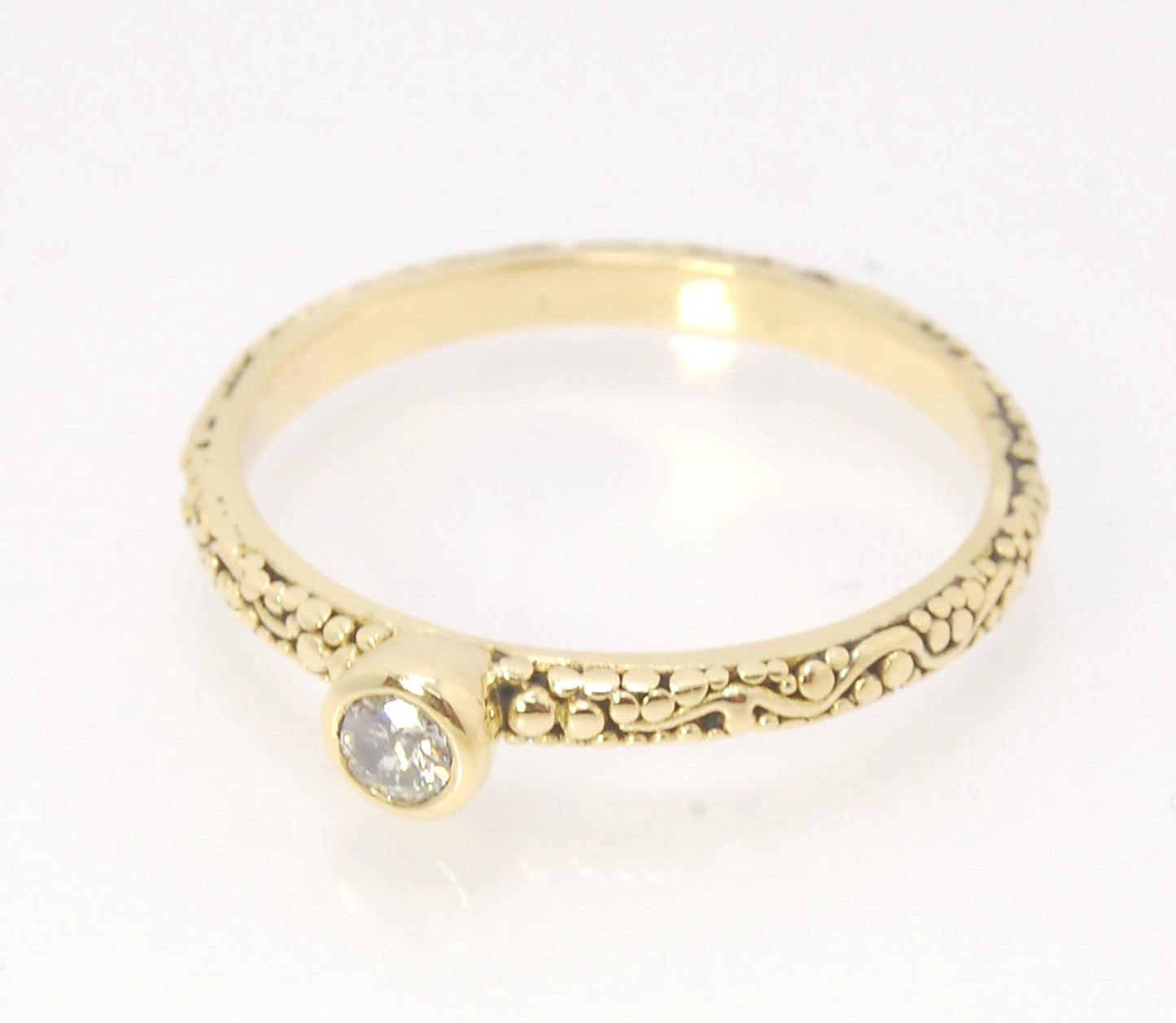 Twining Band Diamond Solitaire Ring in 18k Granulation This is a one-of-a-kind solitaire 18k ring. The twining band is 2mm wide and has a continuous pattern around made with an ancient and unique process of granulation in 18k gold alloyed in my studio. Th