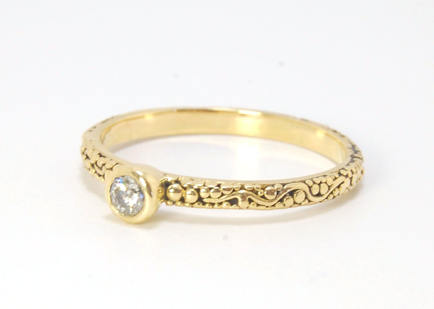 Twining Band Diamond Solitaire Ring in 18k Granulation This is a one-of-a-kind solitaire 18k ring. The twining band is 2mm wide and has a continuous pattern around made with an ancient and unique process of granulation in 18k gold alloyed in my studio. Th