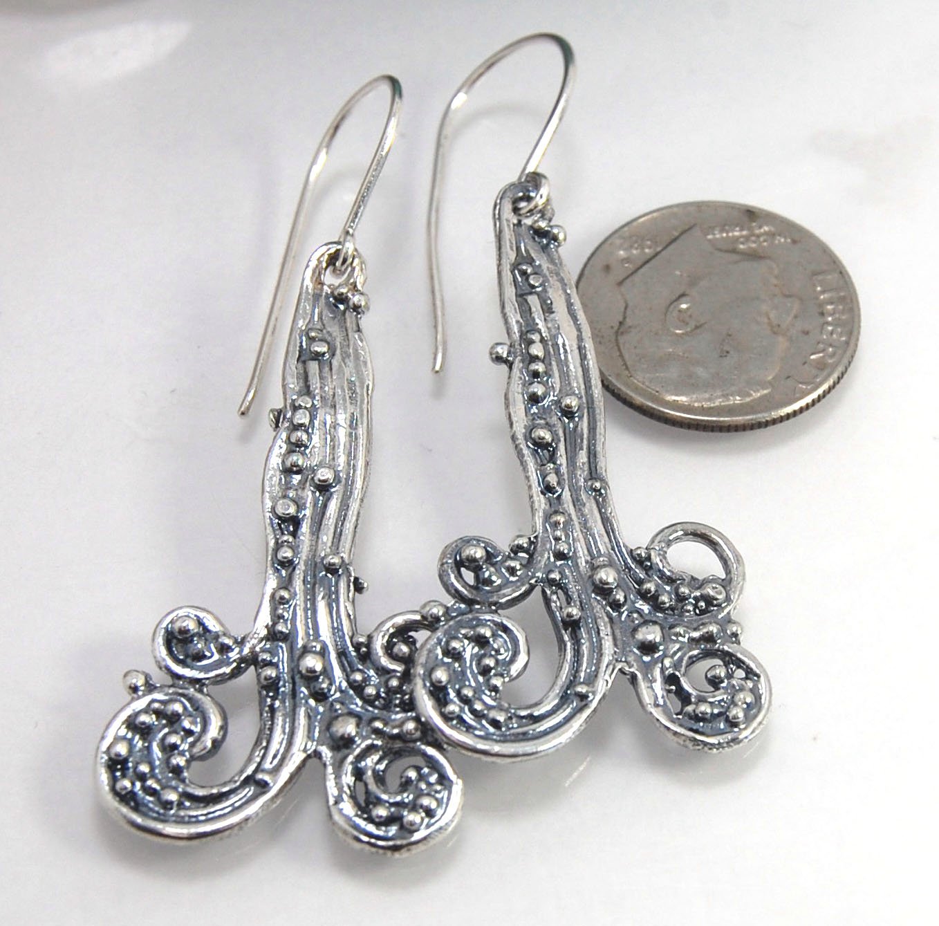 Waterfall Earrings These long Wave Dangles are part of my new work. These are cast versions of my original granulation work, which is then molded for repeat waxes and then cast using the Lost Wax process.These waterfall dangles have a dark patina and are