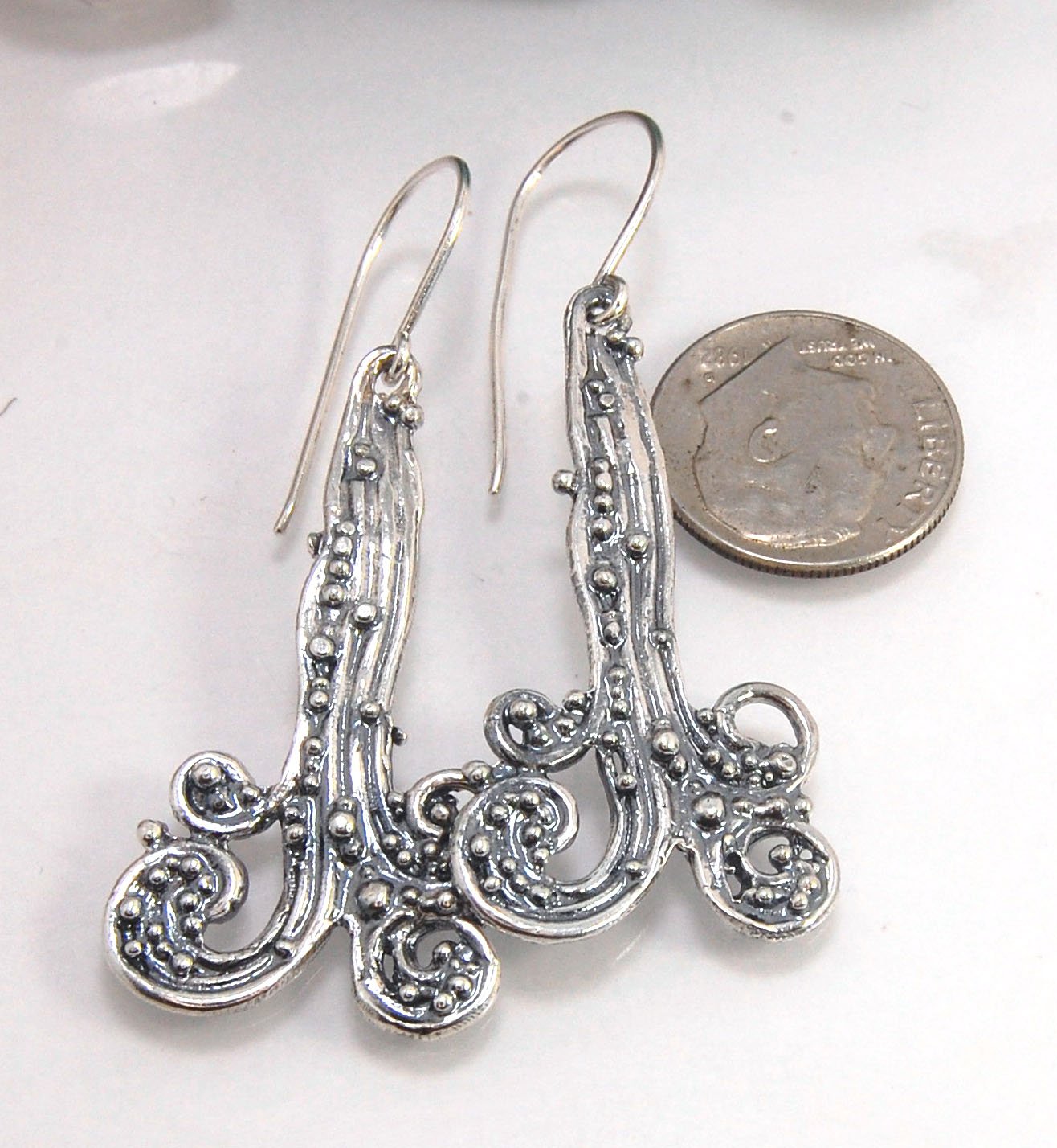 Waterfall Earrings These long Wave Dangles are part of my new work. These are cast versions of my original granulation work, which is then molded for repeat waxes and then cast using the Lost Wax process.These waterfall dangles have a dark patina and are