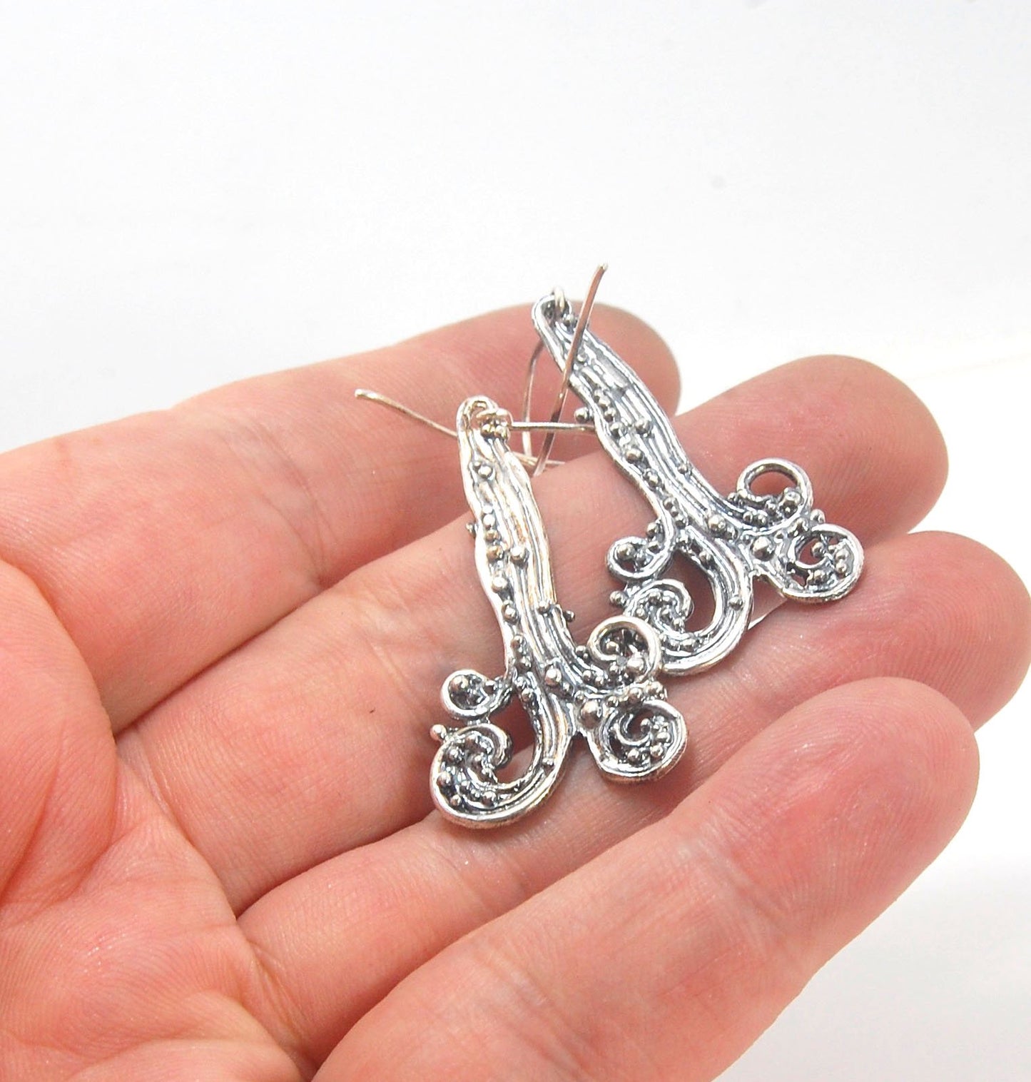 Waterfall Earrings These long Wave Dangles are part of my new work. These are cast versions of my original granulation work, which is then molded for repeat waxes and then cast using the Lost Wax process.These waterfall dangles have a dark patina and are